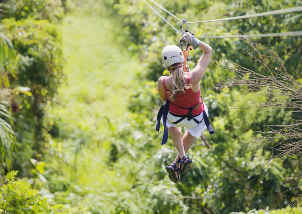 Woman ziplining in a park