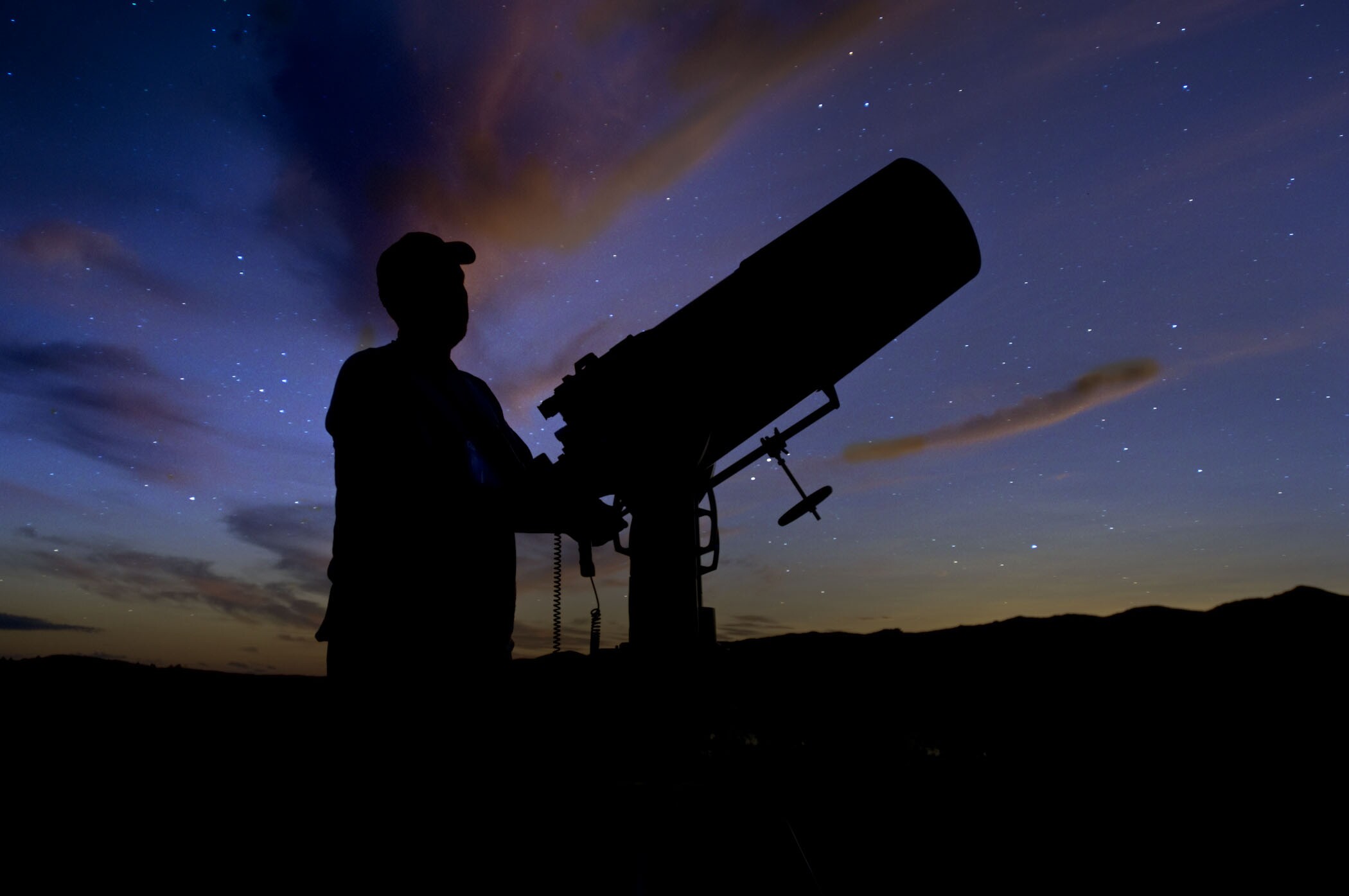 Man viewing starry sky through telescope