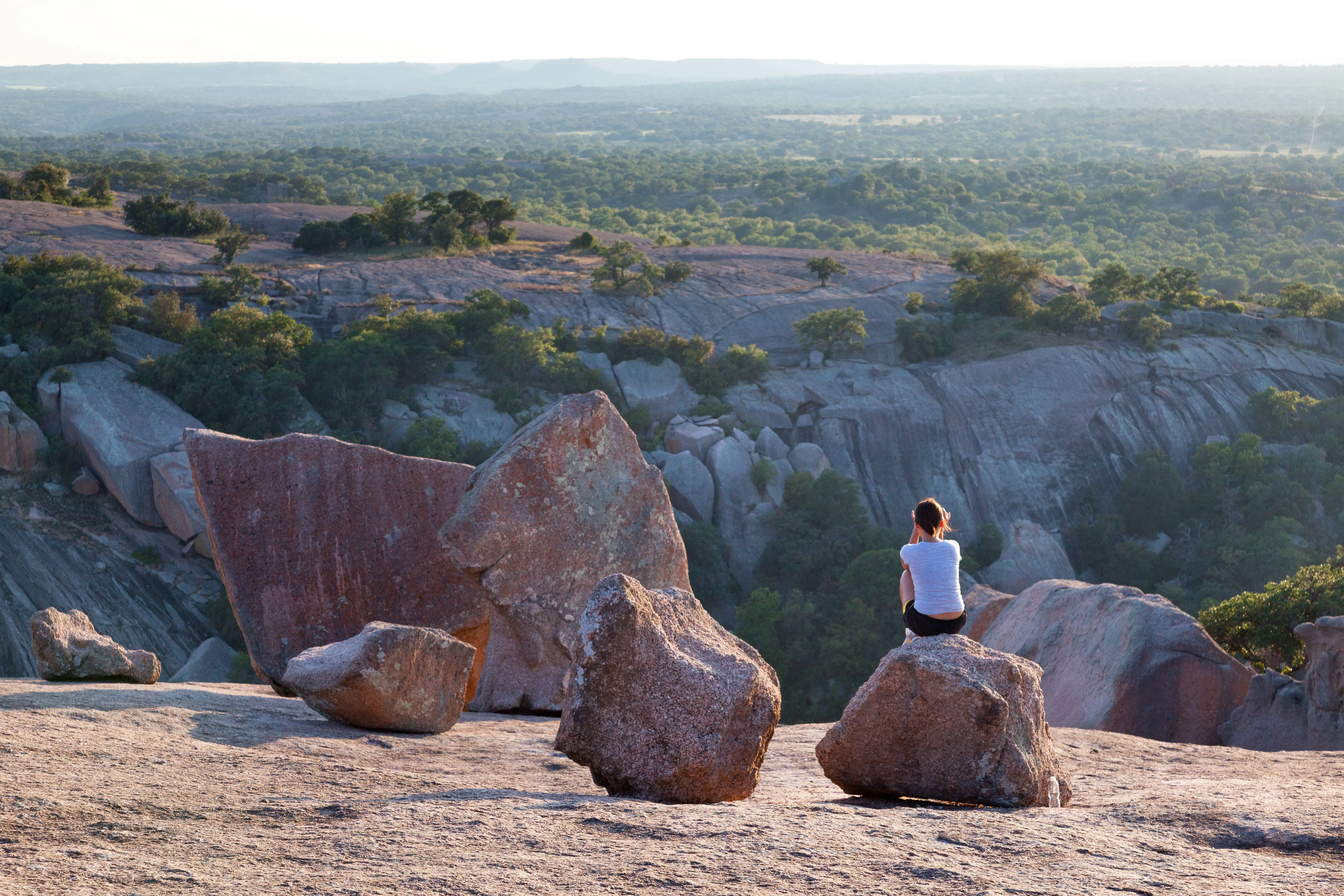 Woman sitting on rock taking in view at Enchanted Rock