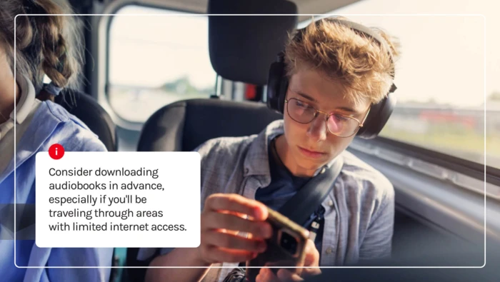 A car passenger listening to an audiobook with headphones during a road trip. 