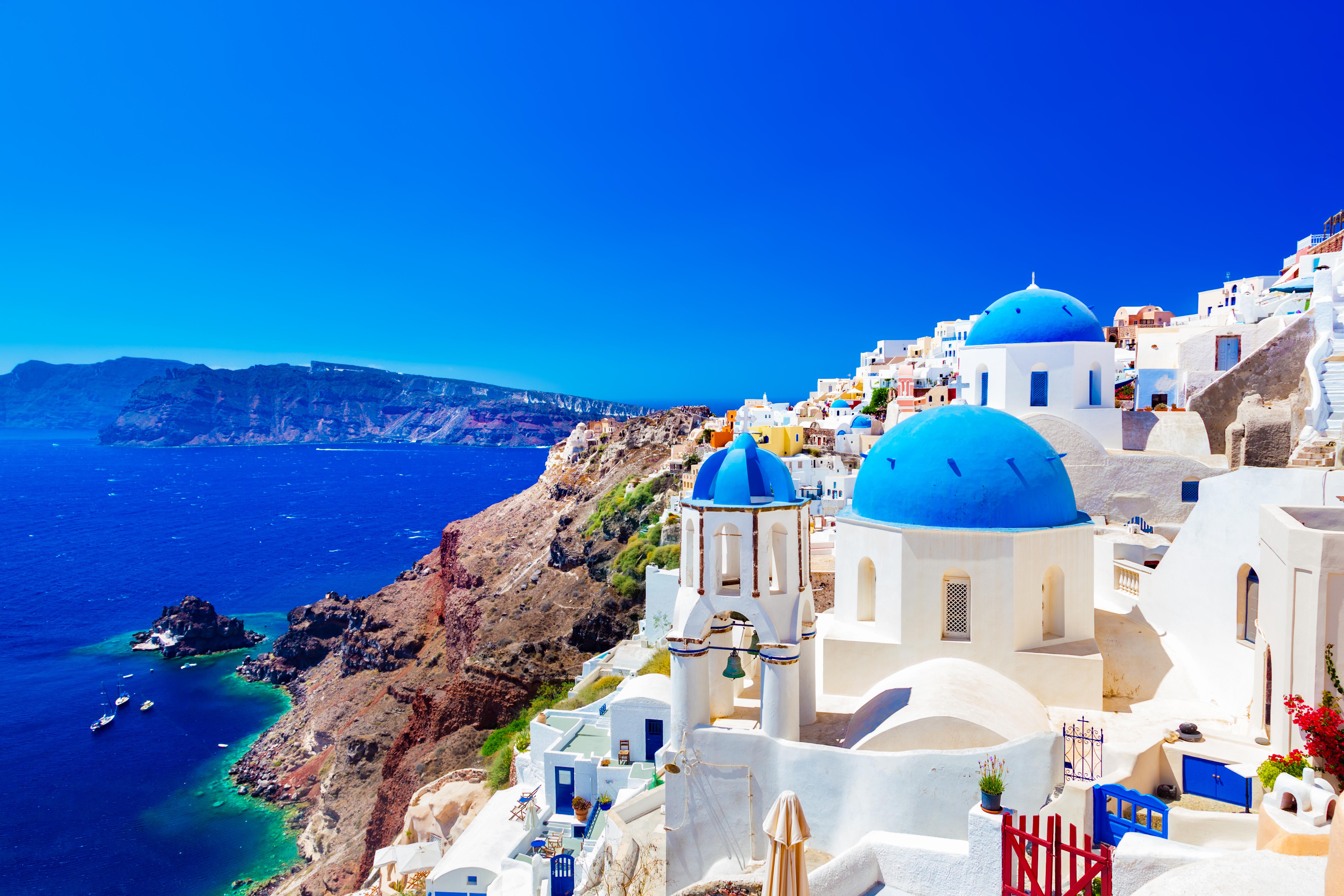 Oia town on Santorini island, Greece. Traditional and famous houses and churches with blue domes over the Caldera, Aegean sea