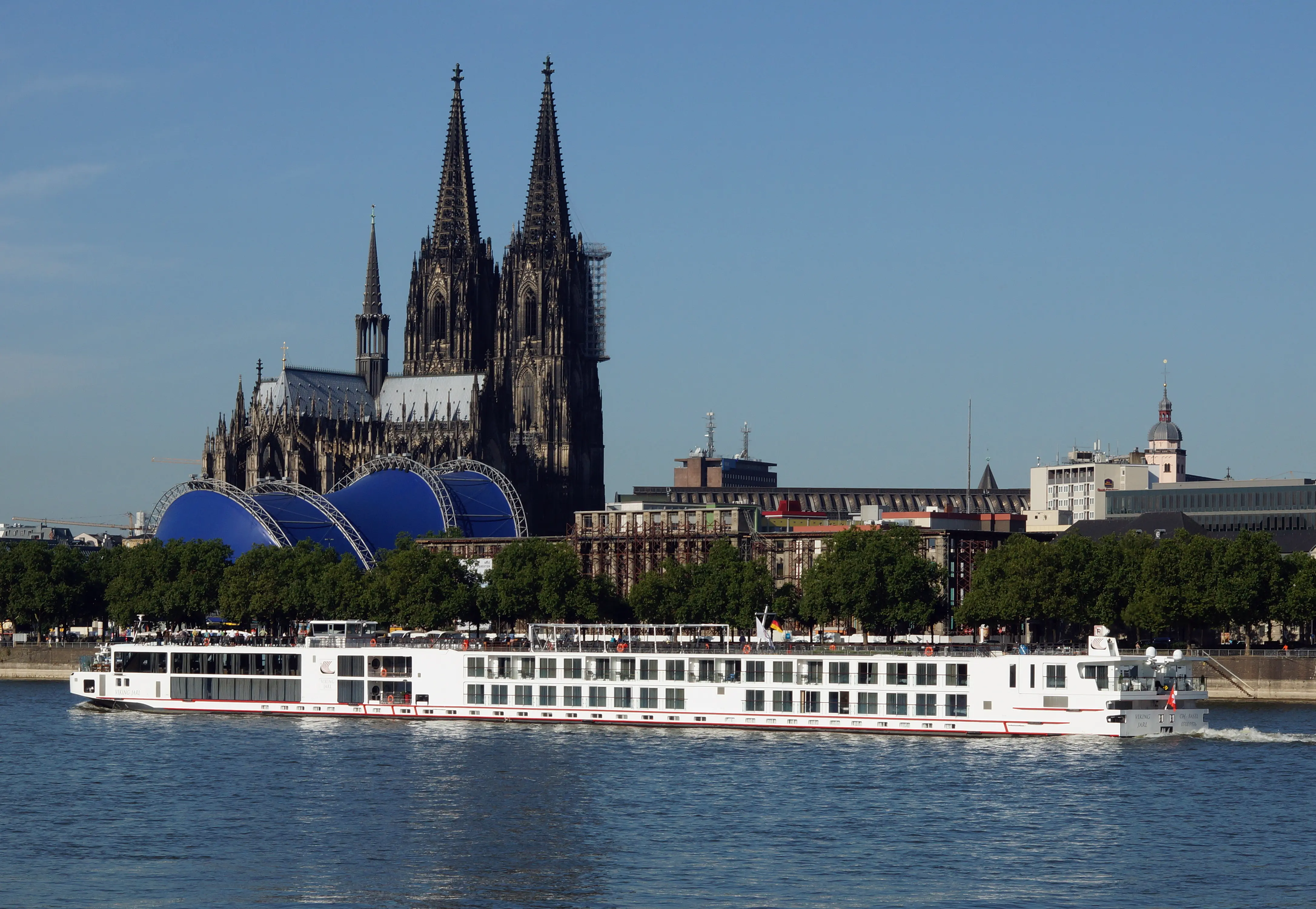 Image of a Viking River Cruises boat passing the Cologne Cathedral, in Cologne, Germany.