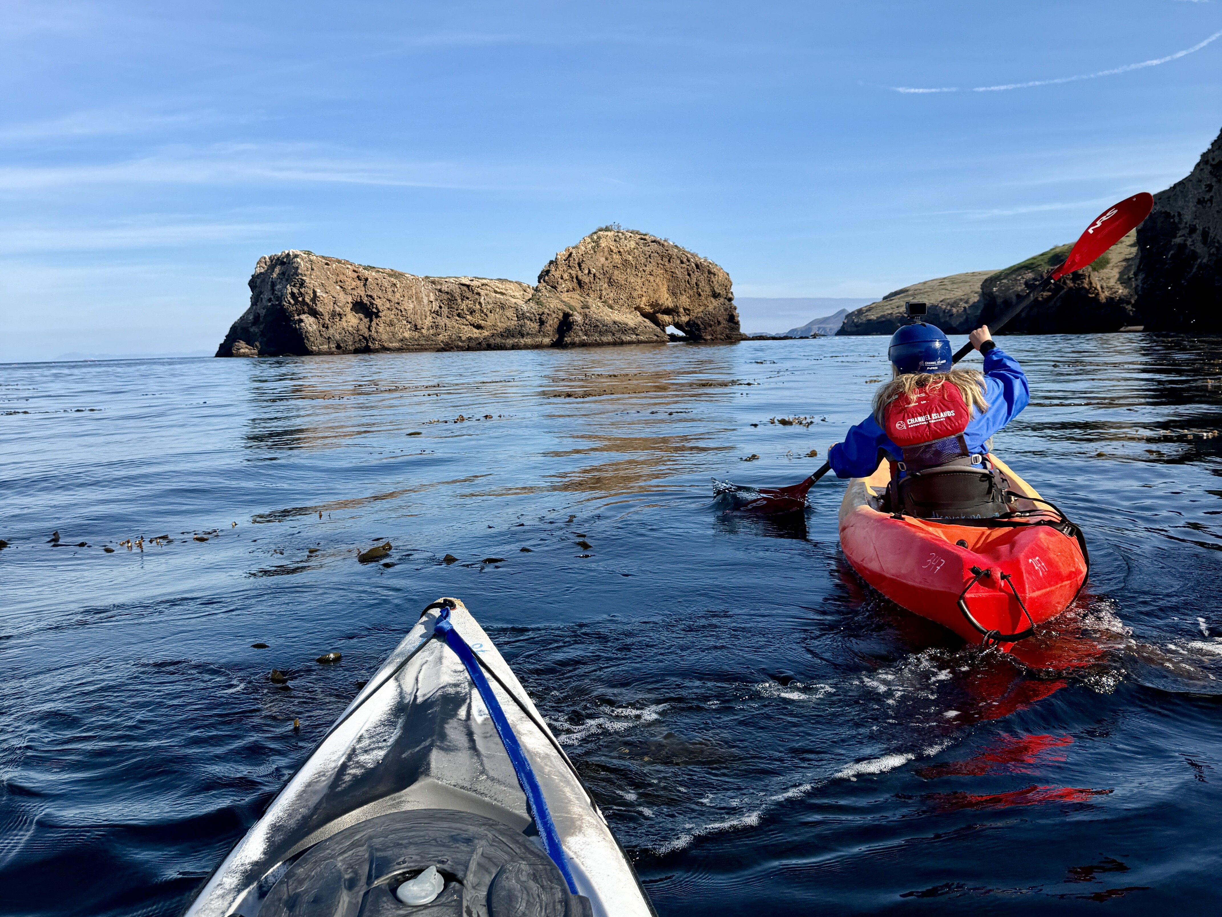Jennifer Broome kayaking in Channel Islands National Park. Cliffs and grottos line the shore.