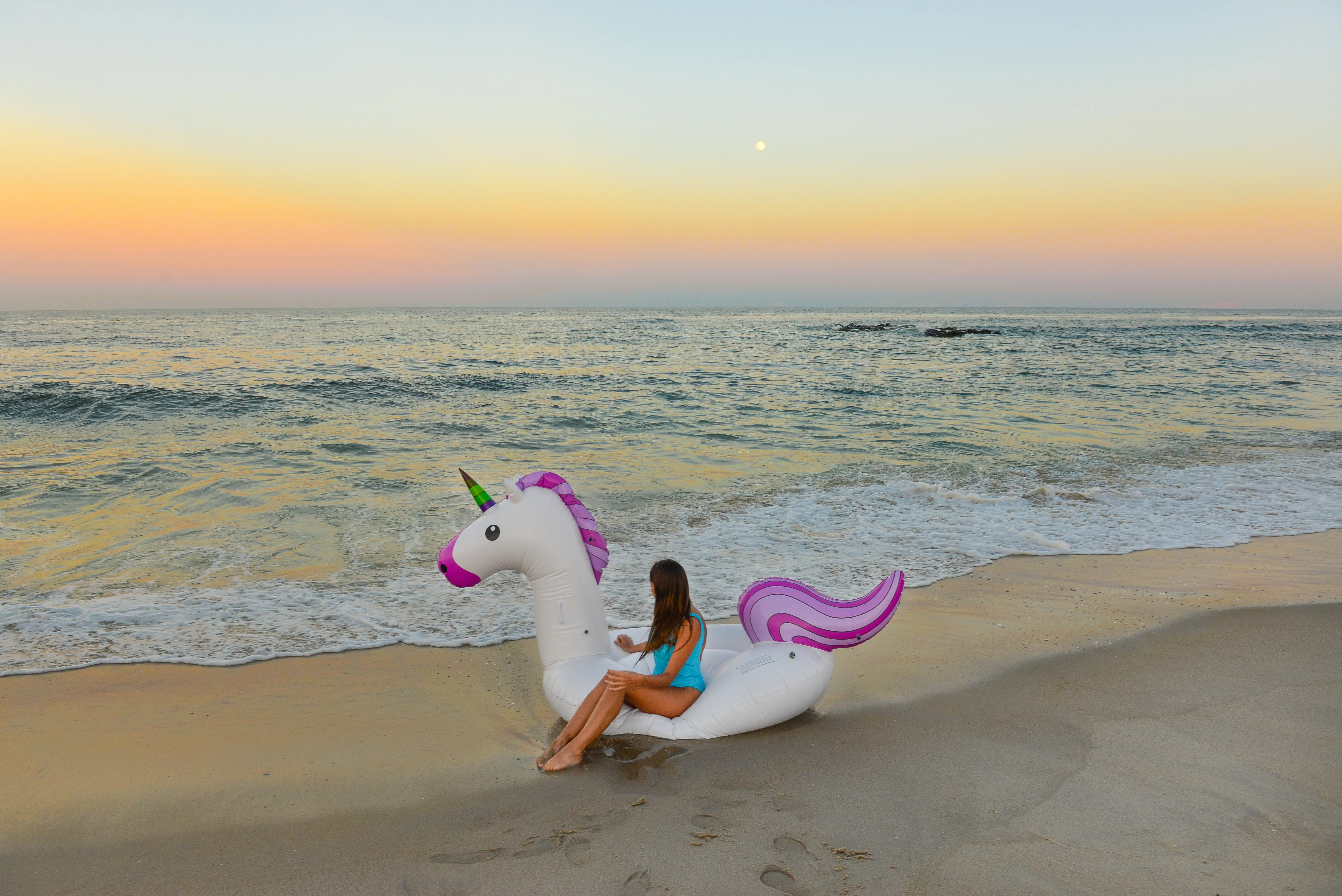 Image of a woman sitting on a pool inflatable at the shore of Spring Lake, New Jersey.
