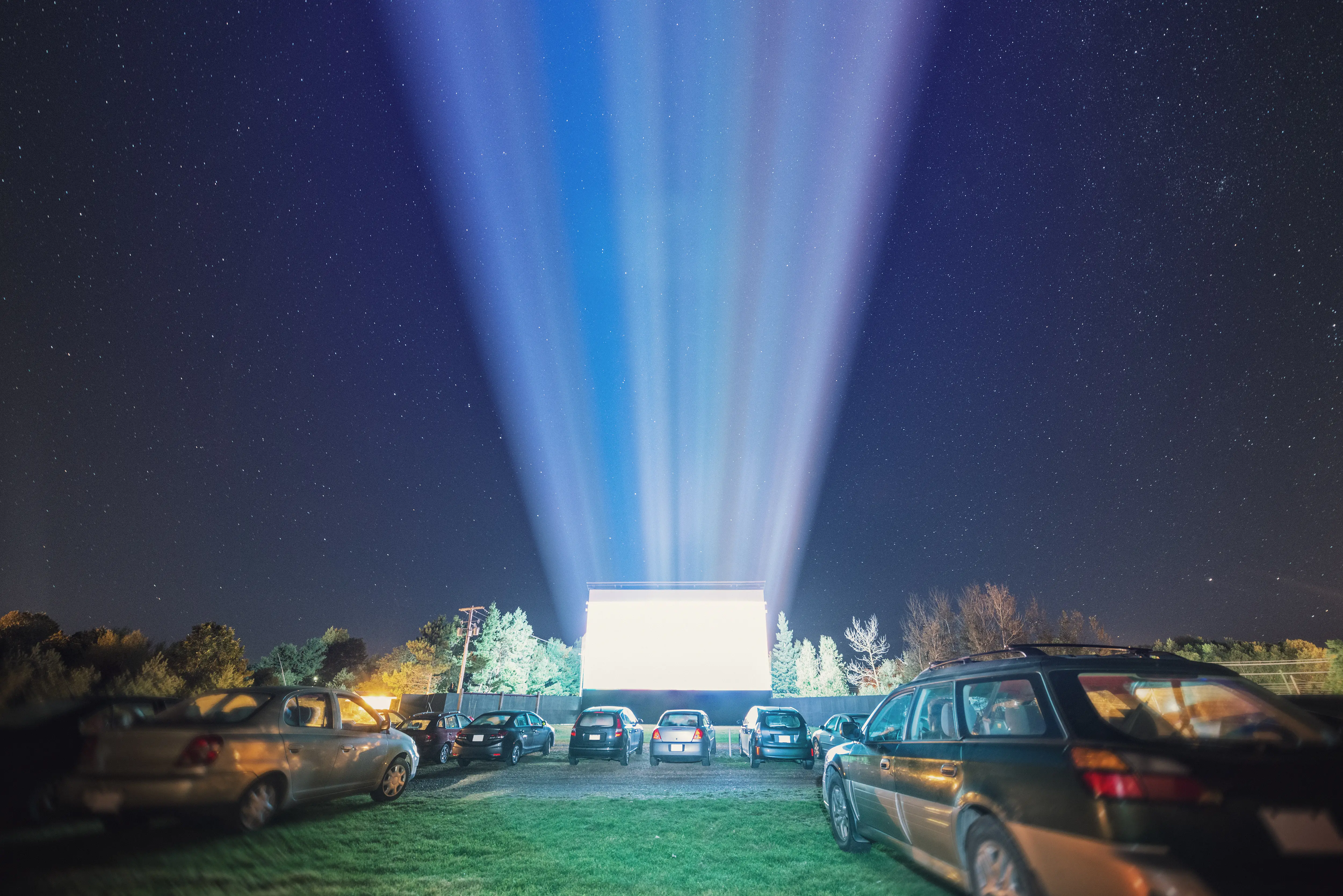 Image of cars parked for a nighttime drive-in movie.