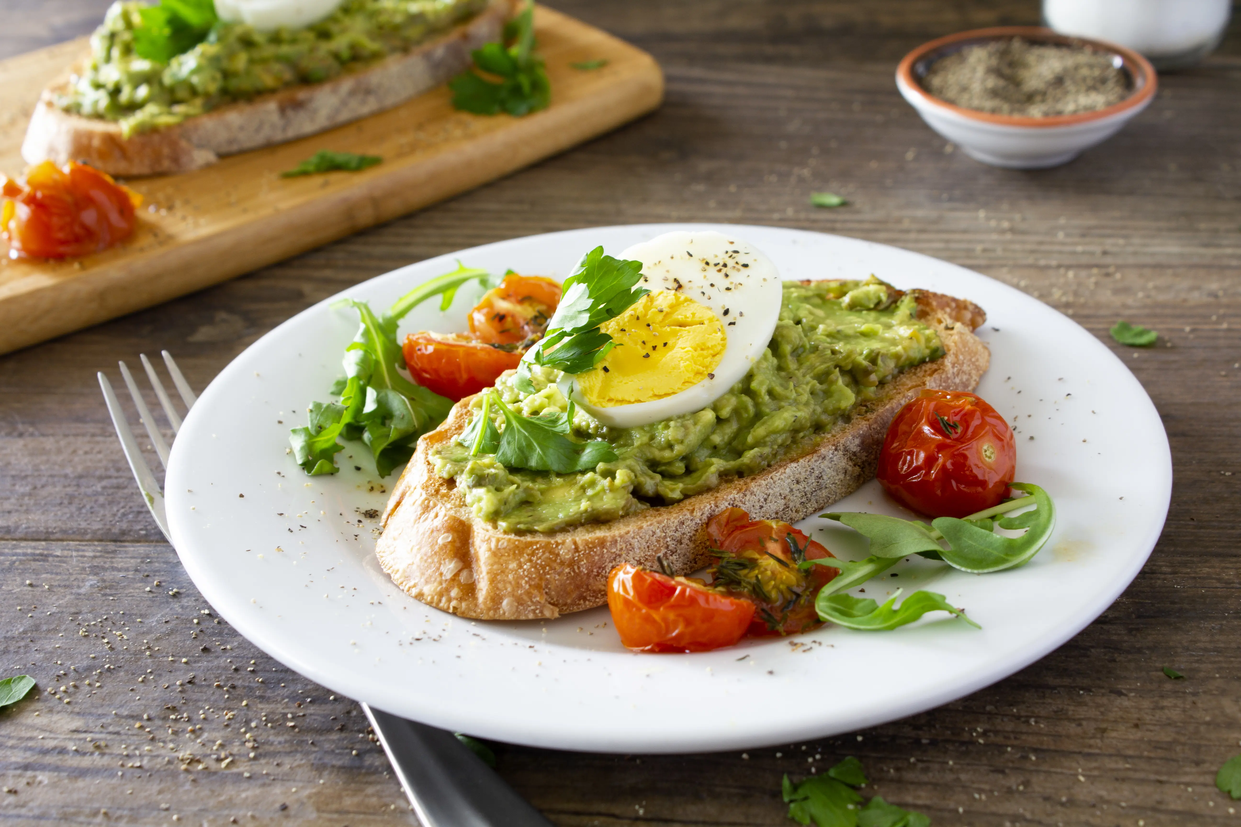Image of Avocado toast with eggs and roasted tomatoes.