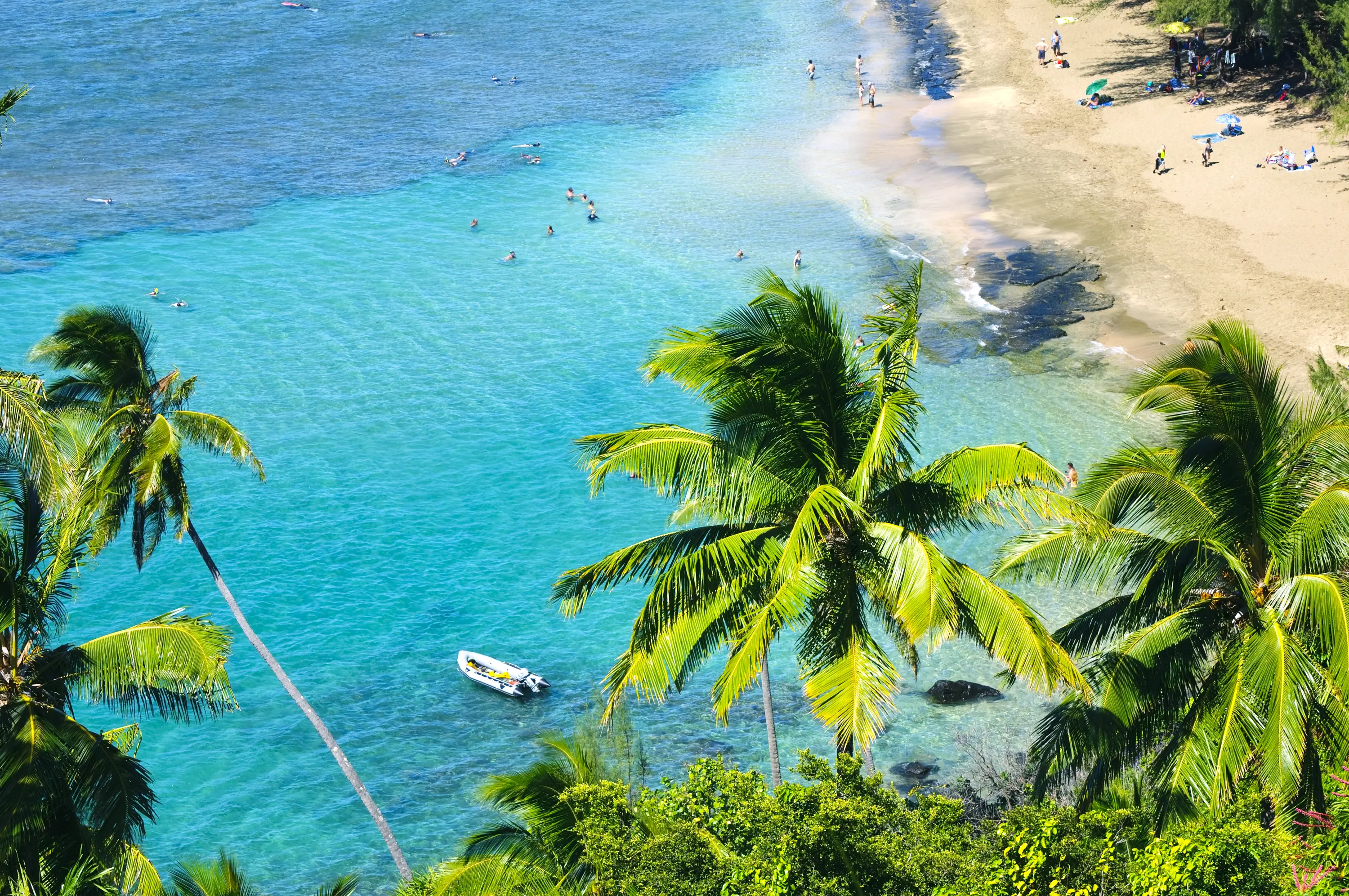People on the beach and in the water, snorkeling and swimming, at Ke'e Beach