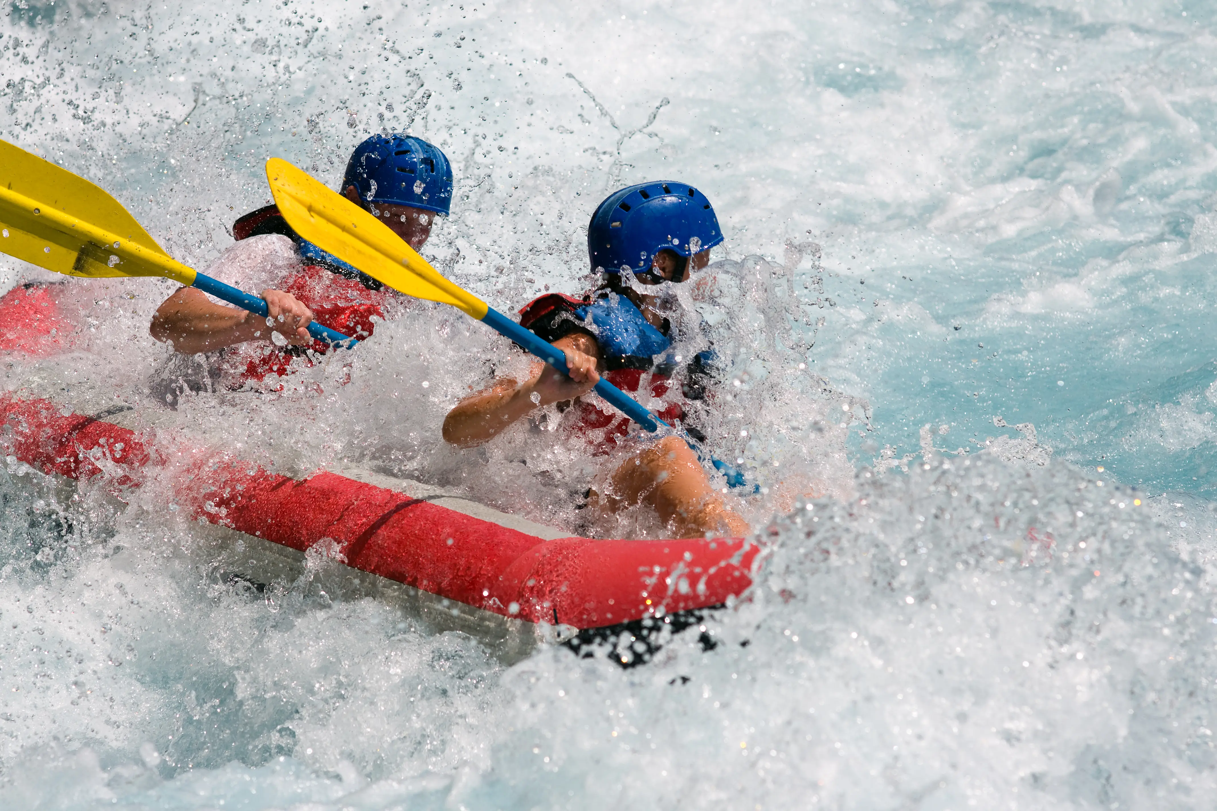 Two people rafting on white water for sport and exhilaration.