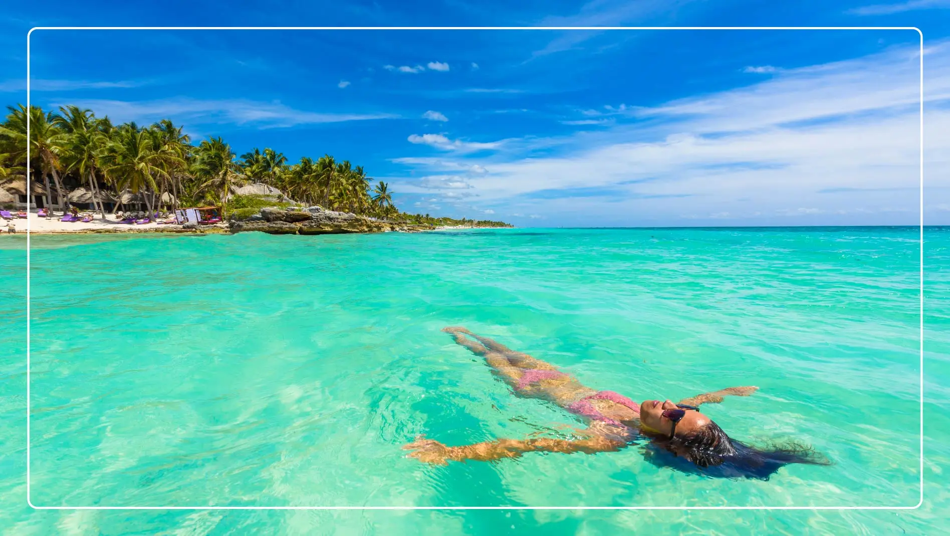 A woman floats in the turquoise ocean in Riviera Maya, Mexico.