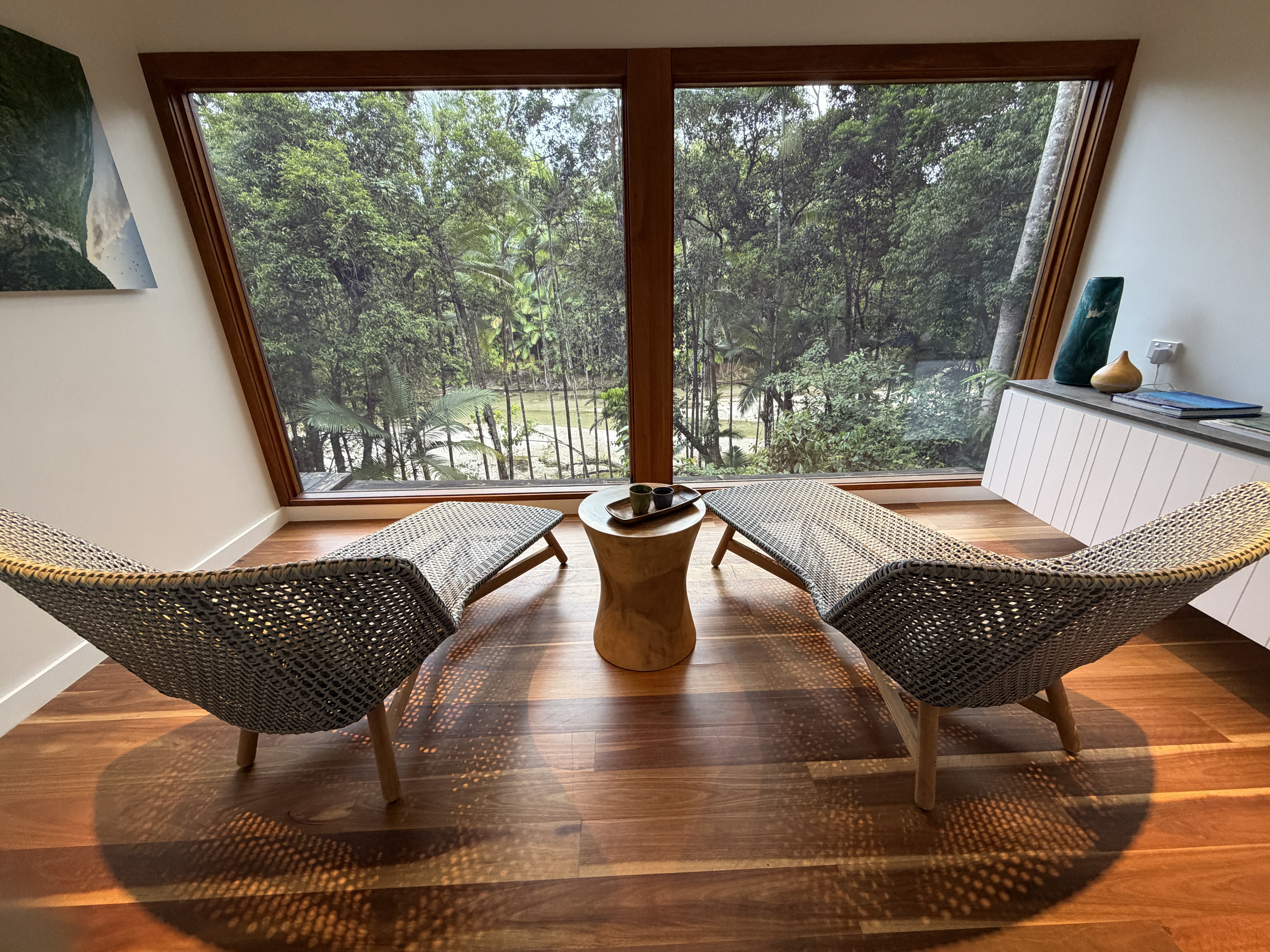 View of trees from hotel window overlooking loungers
