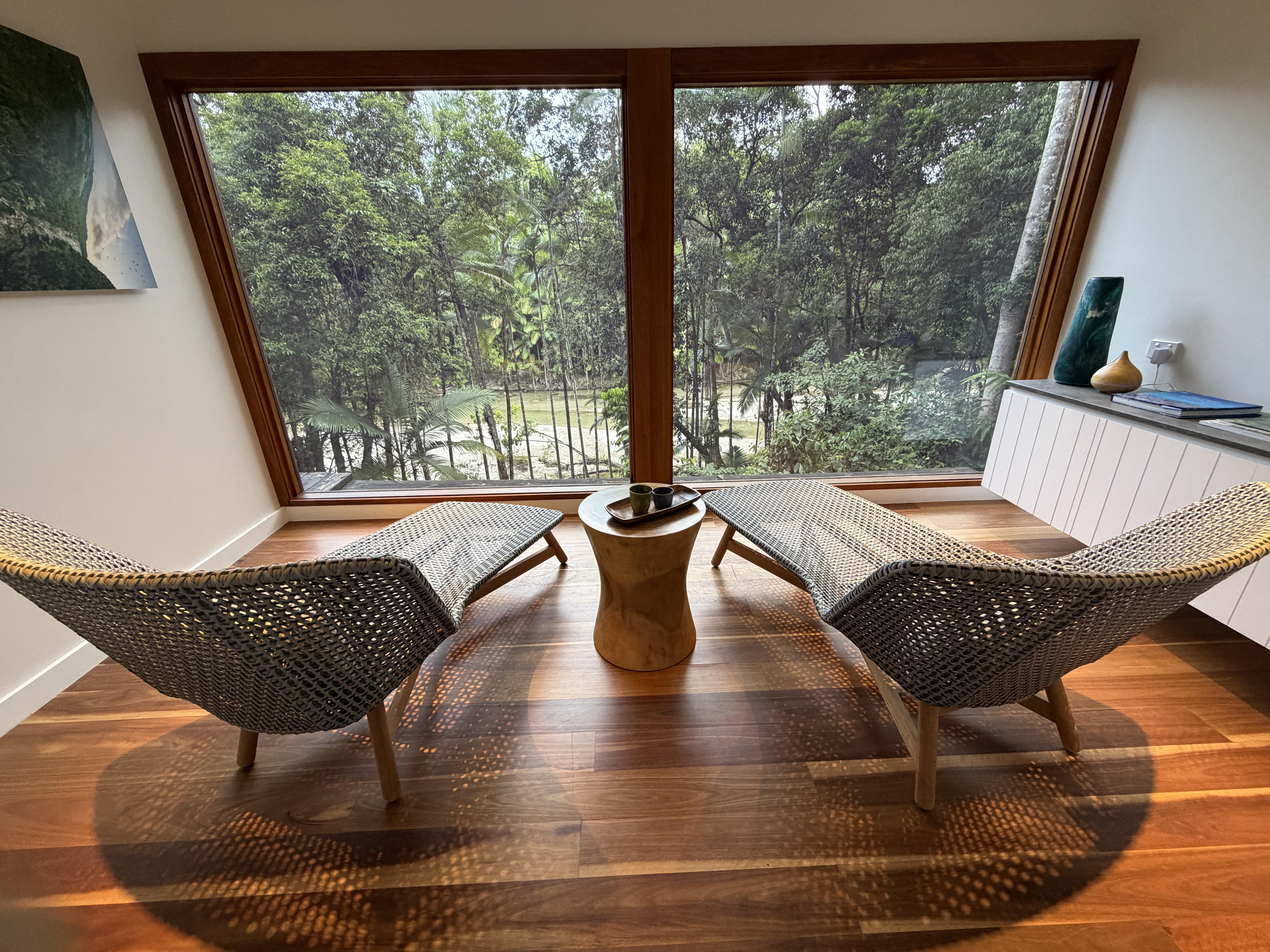 View of trees from hotel window overlooking loungers