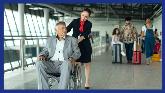 A flight attendant helping a passenger in a wheelchair to his destination.