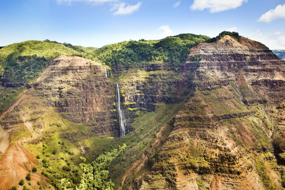 Colorful gorge with a waterfall in Waimea Canyon State Park.