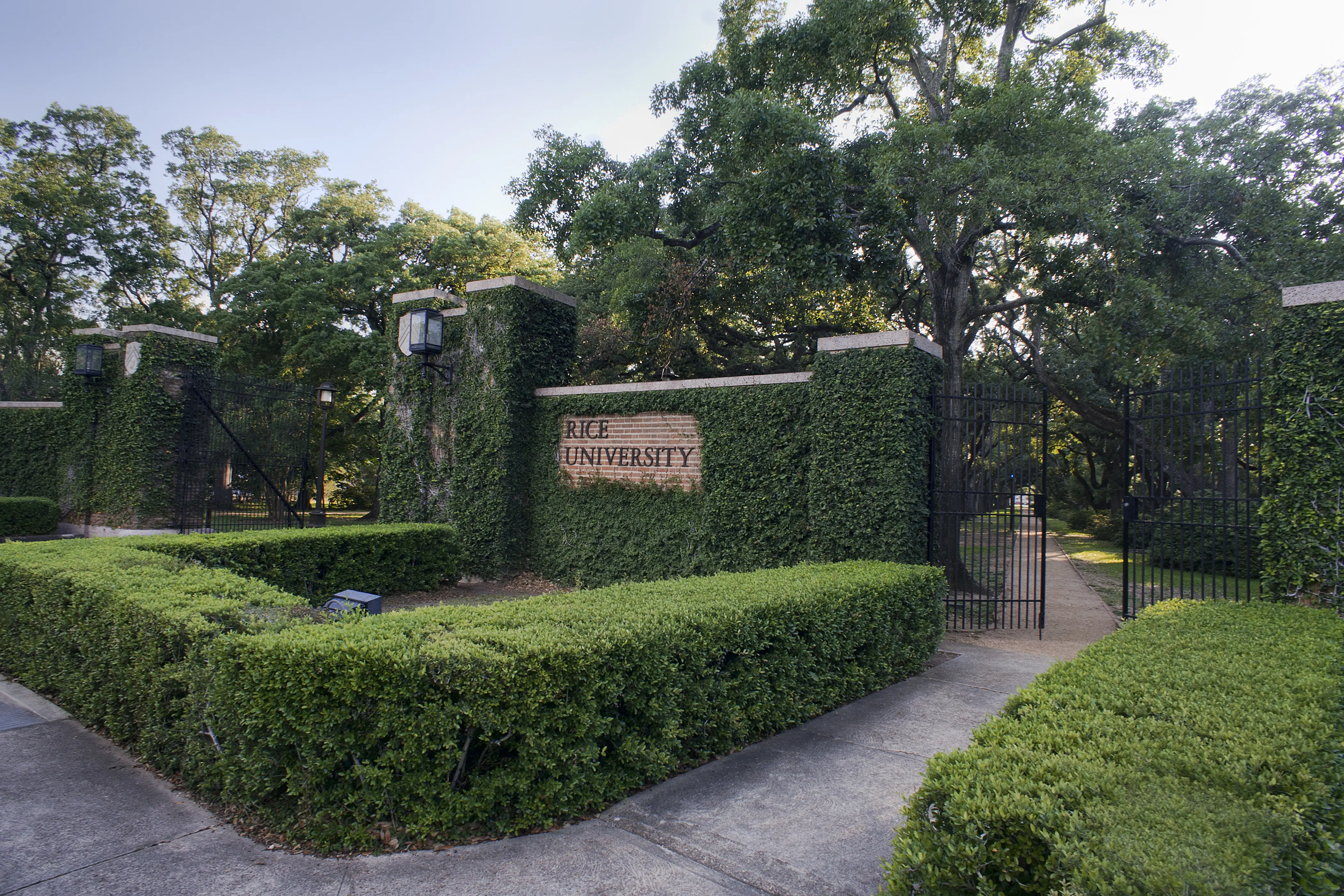 Image of the Rice University main entrance, covered in green plant life.