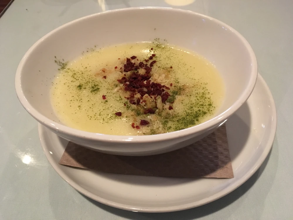Potato & leek soup with crispy prosciutto, blue crab, garlic oil, & leek powder