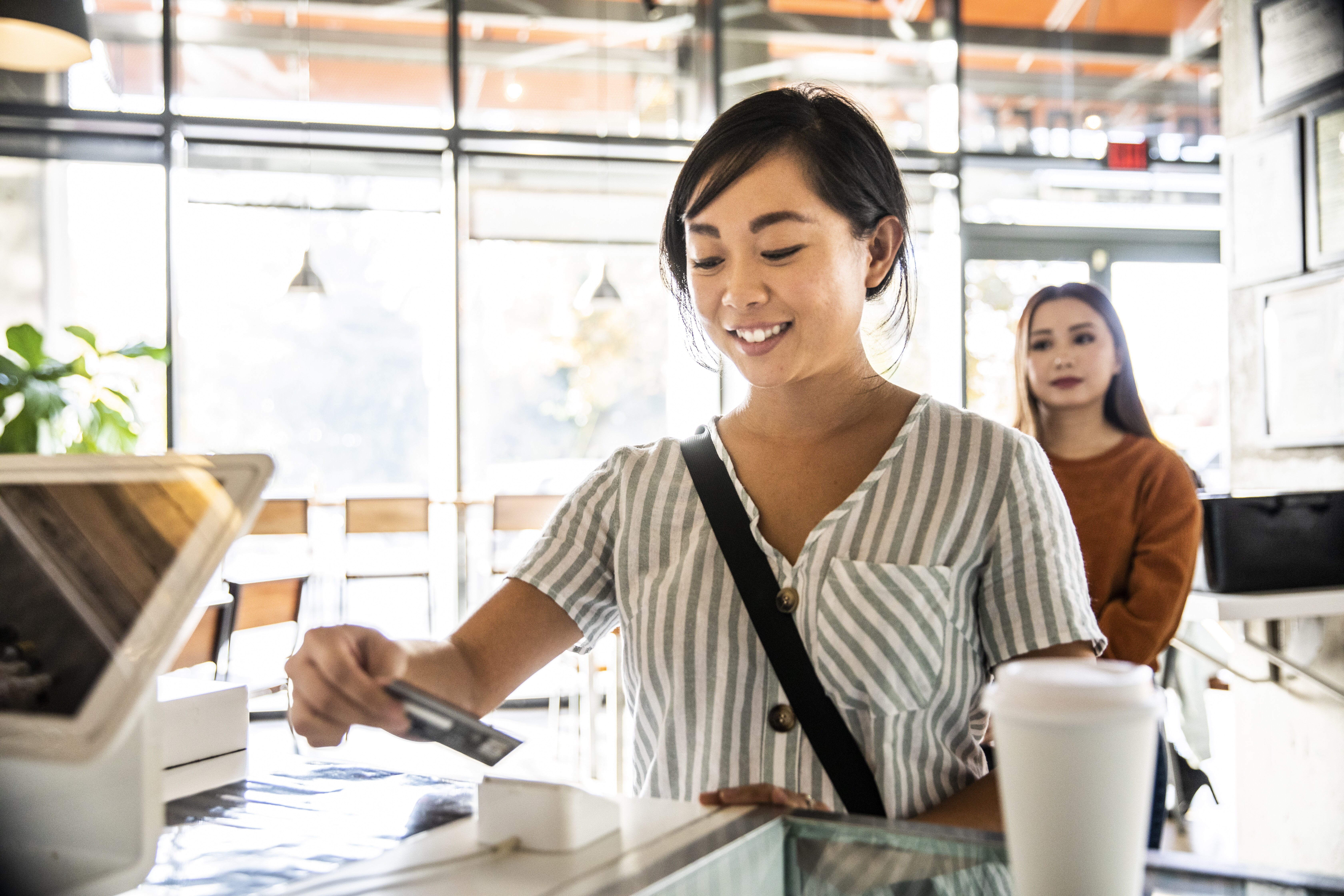 Image of a woman making a purchase with a credit card.