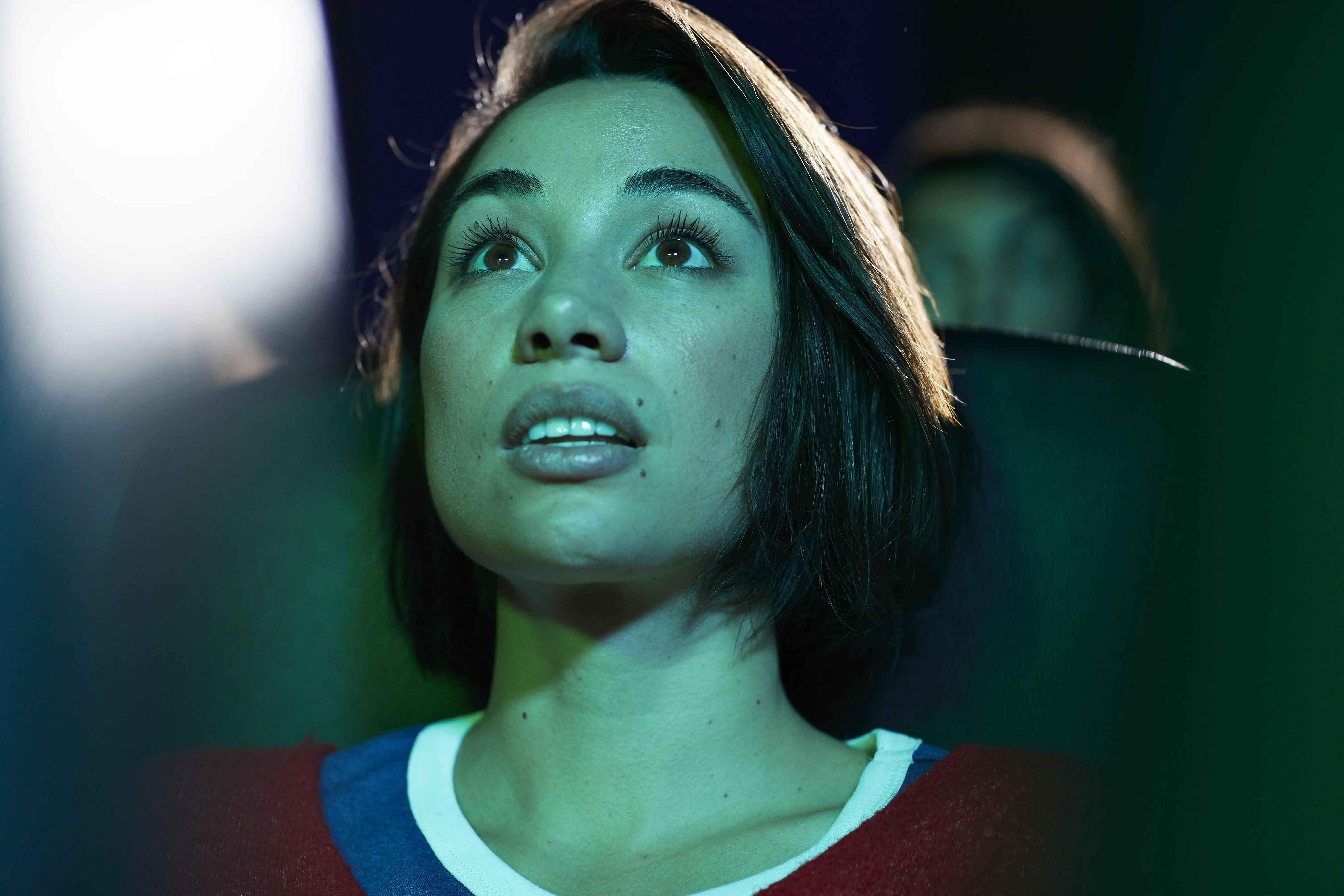 Image of a woman sitting in a theater and looking immersed.
