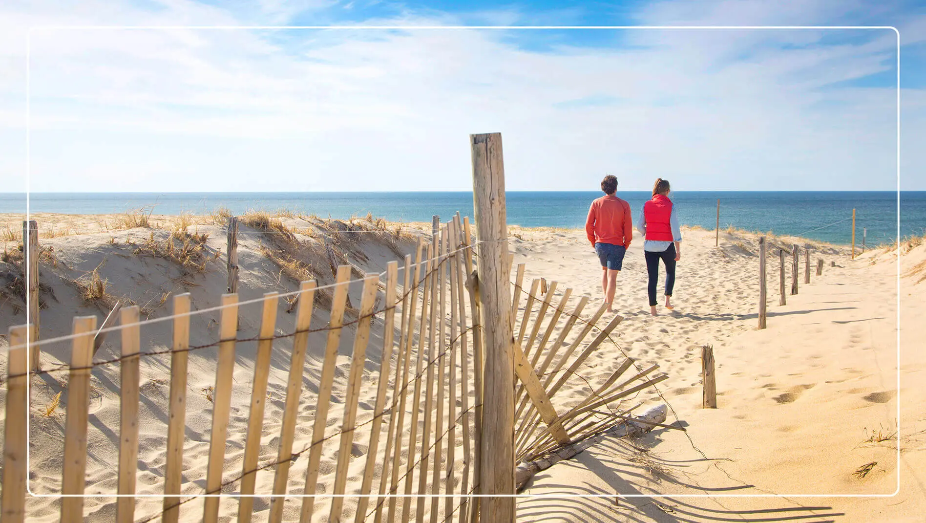 A couple walks on the sand toward the water on Cape Cod National Seashore.