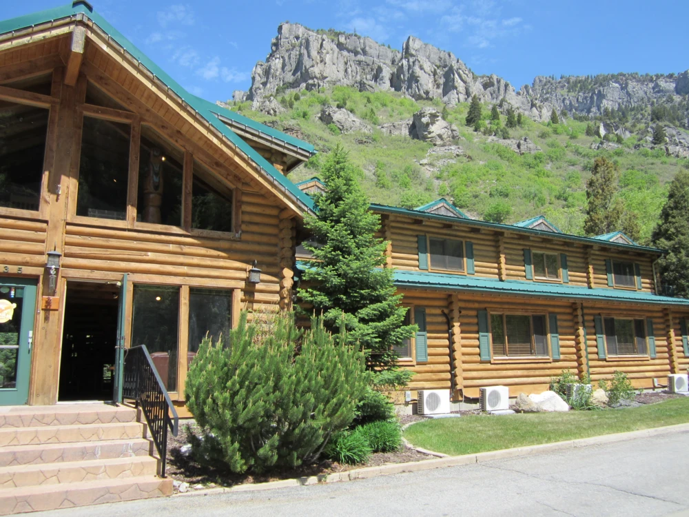 Front entrance of Alaskan Inn Bed and Breakfast with rocky peaks behind it in Ogden, Utah.
