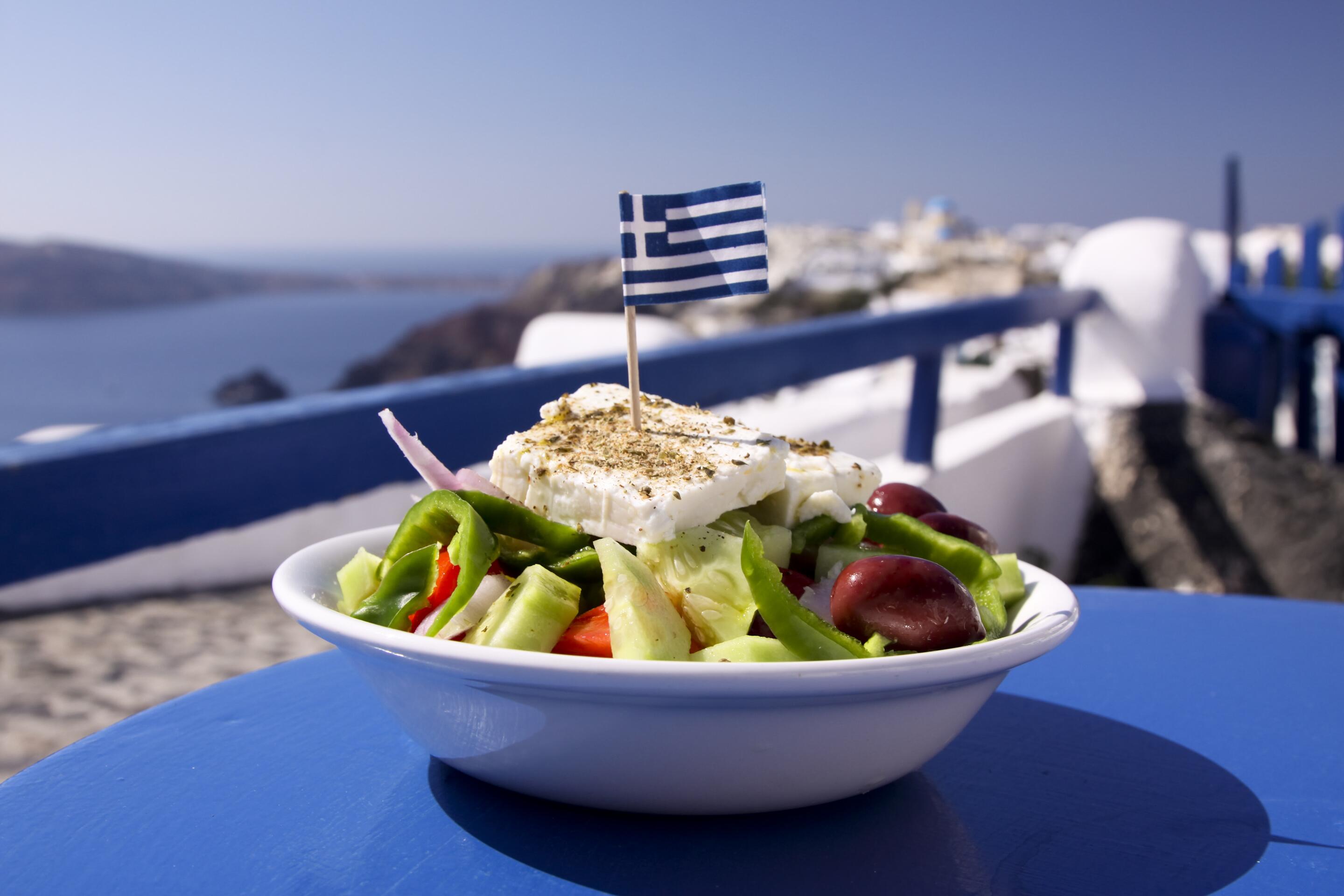 Photo of a Greek salad by the water in Santorini, Greece