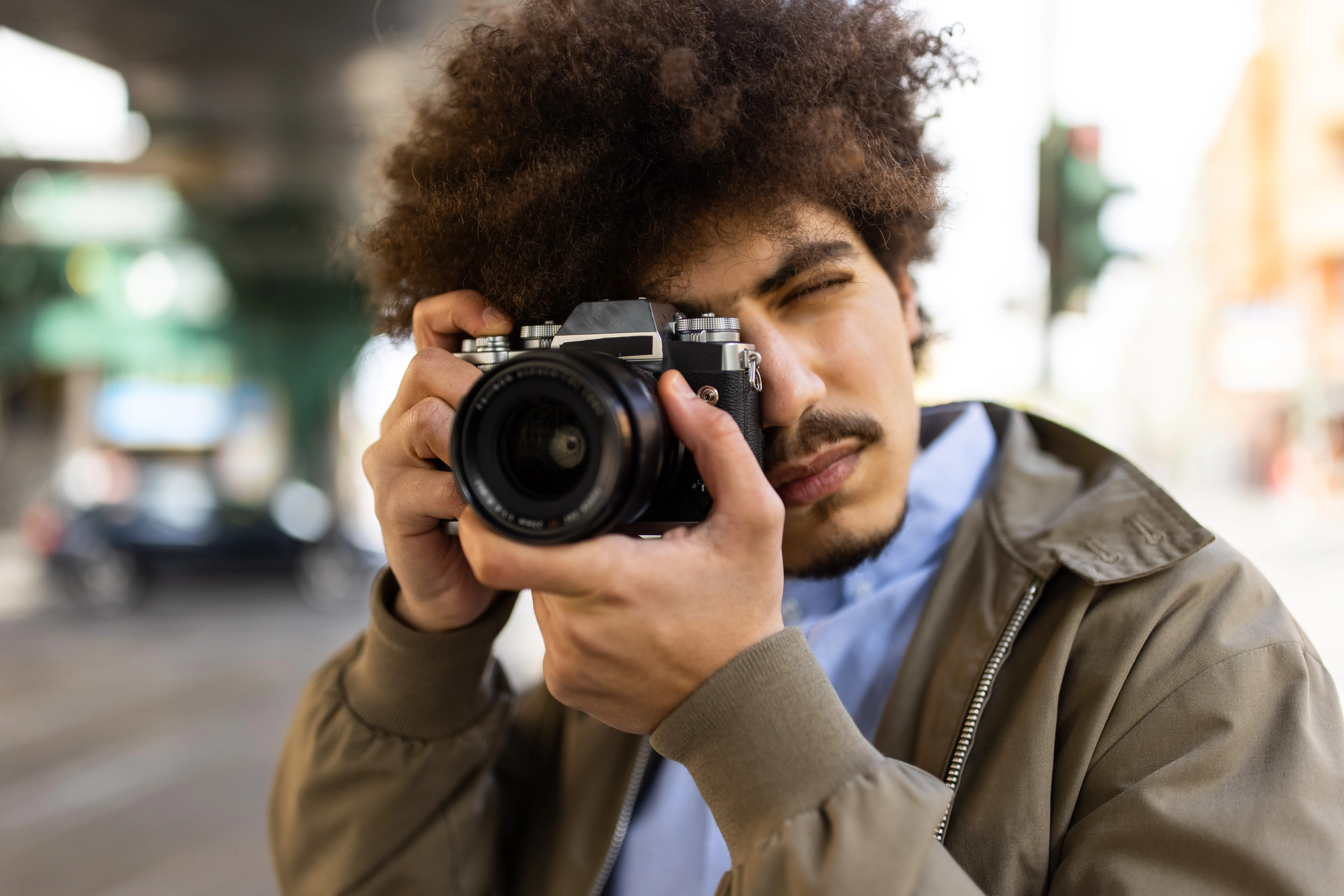 Image of a man taking a picture in a city setting.