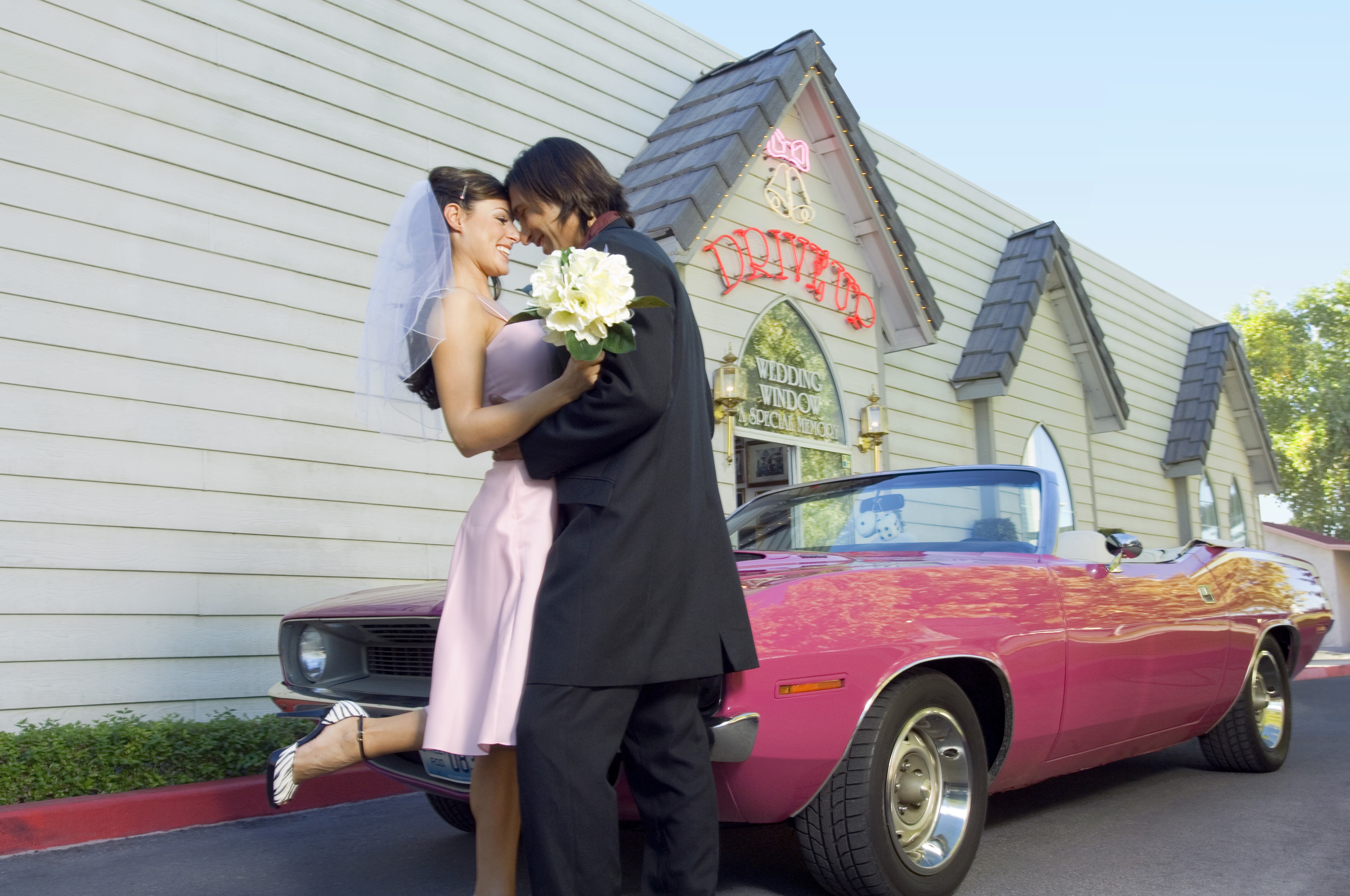 Image of a newlywed couple at a drive-up wedding venue.