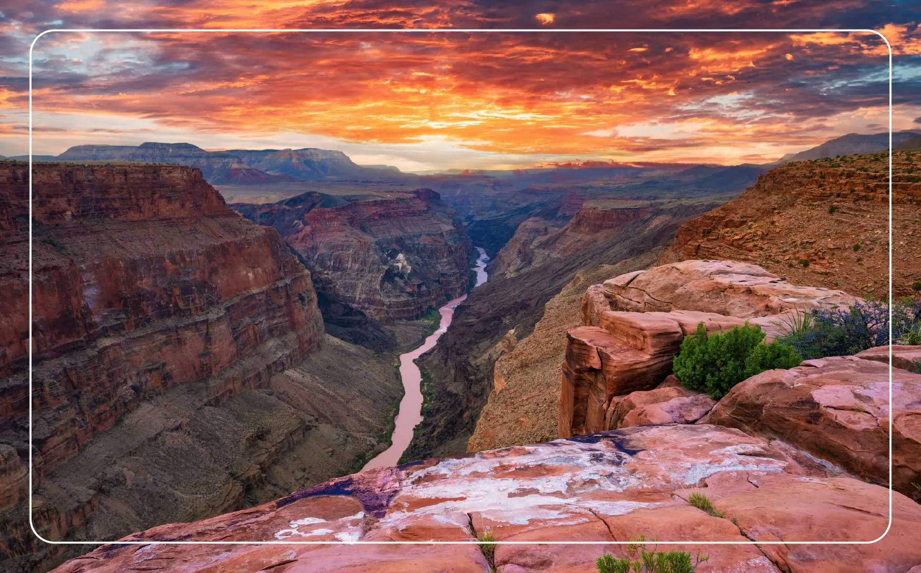 Breathtaking view of the Grand Canyon dramatic cliffs and the winding Colorado River at sunset.