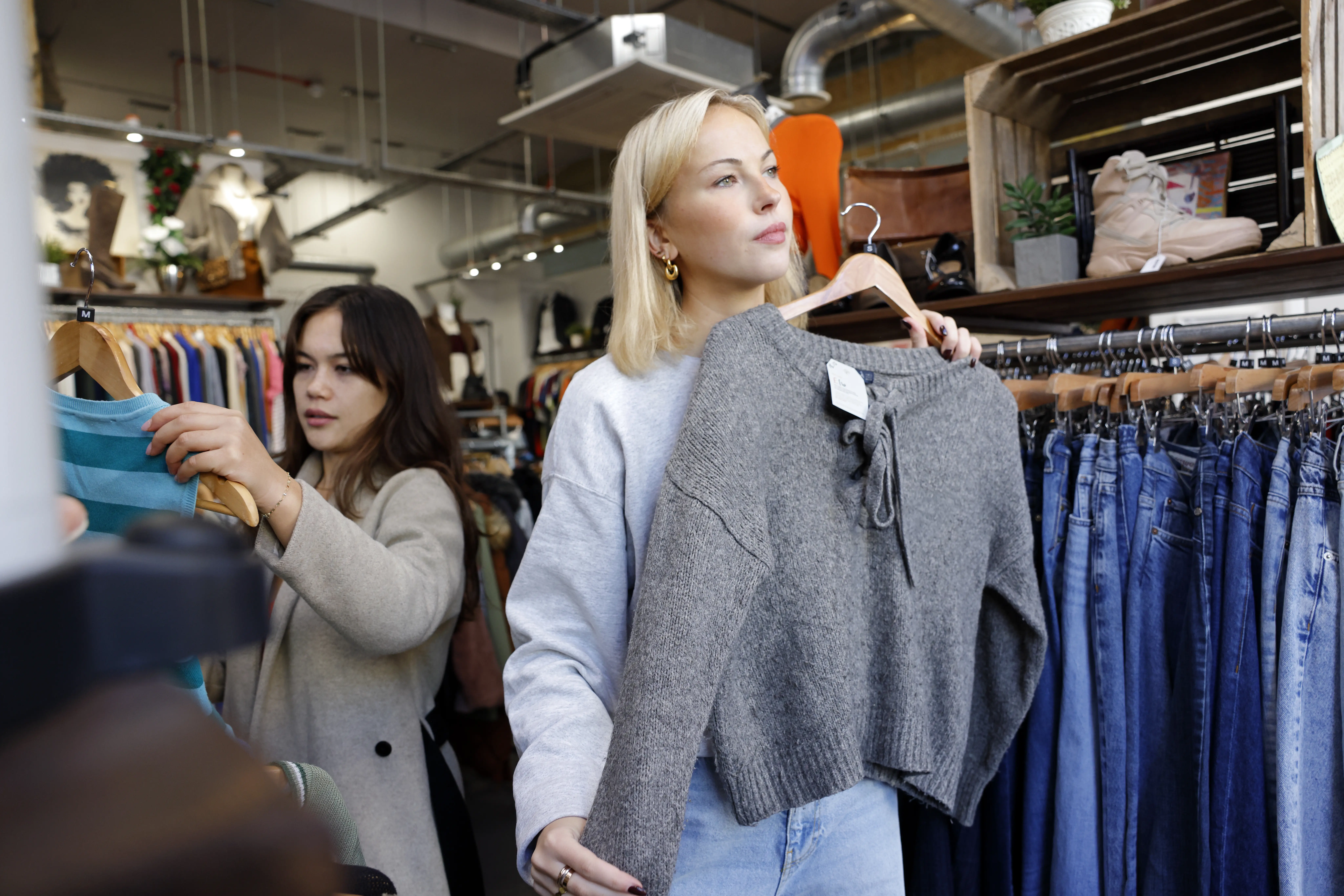 Image of two women shopping at an indoor clothing store.