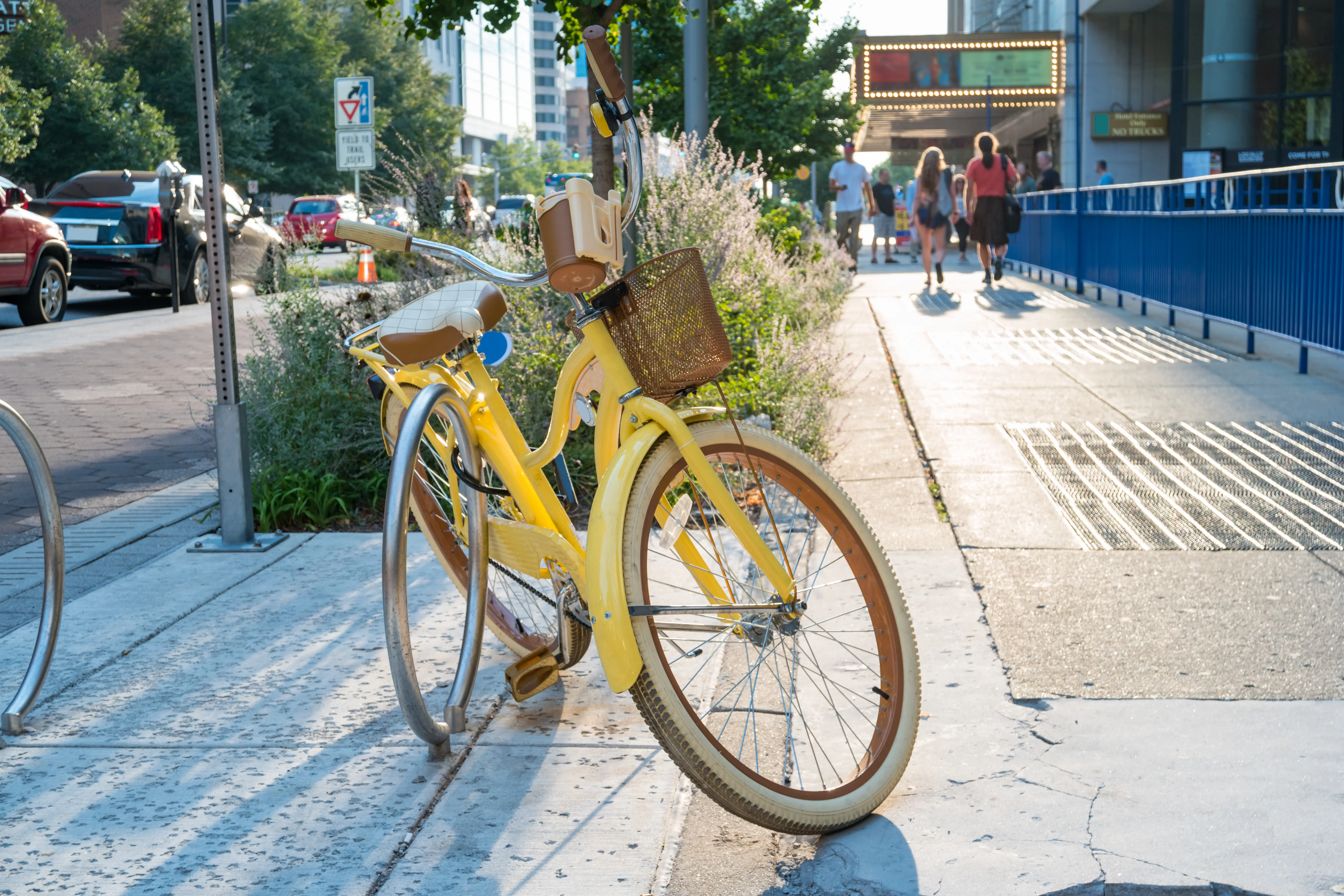Locked yellow bicycle in downtown Indianapolis with out of focus pedestrians in the background, Indiana, USA