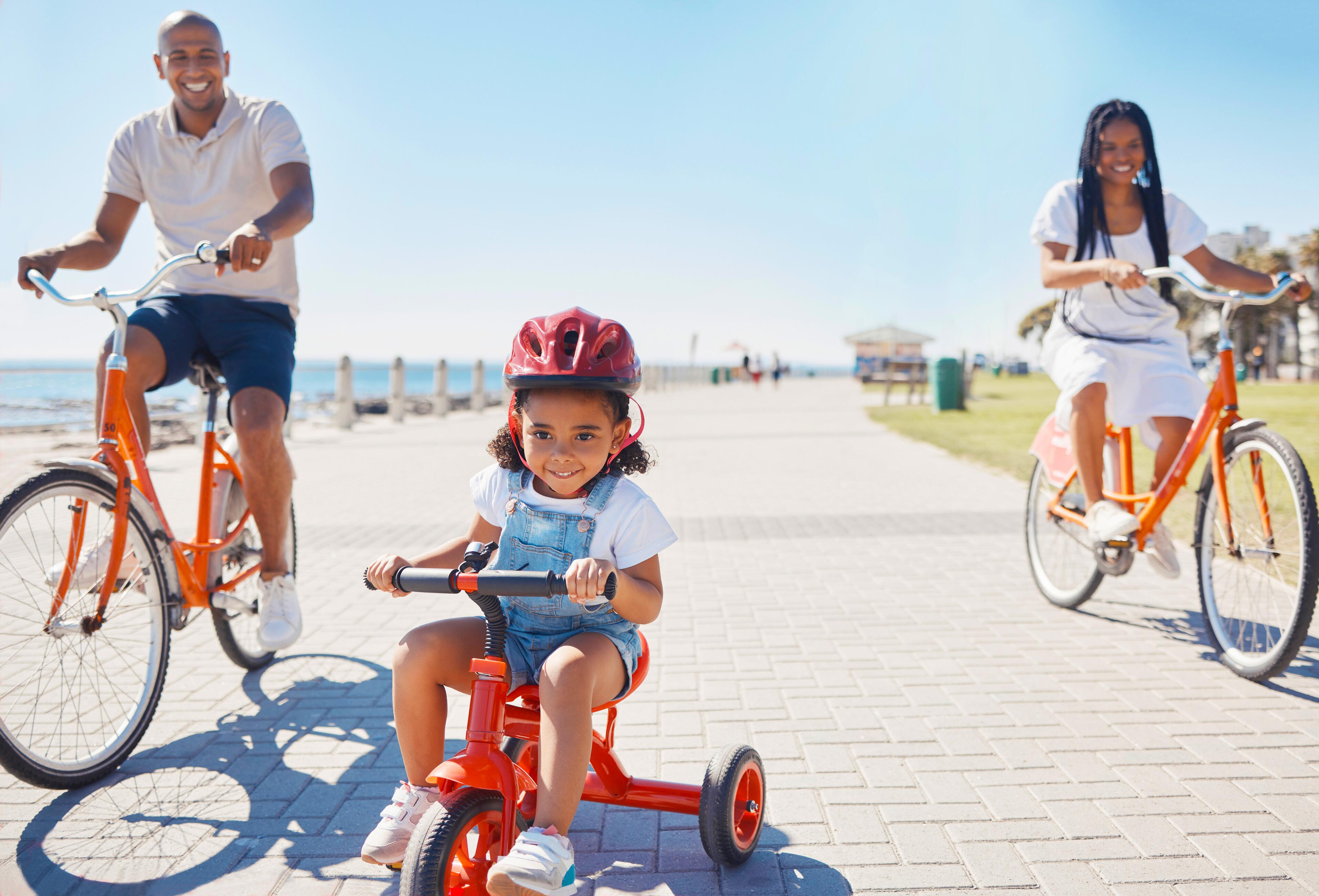 Family riding their bikes on the promenade pathway in the summer