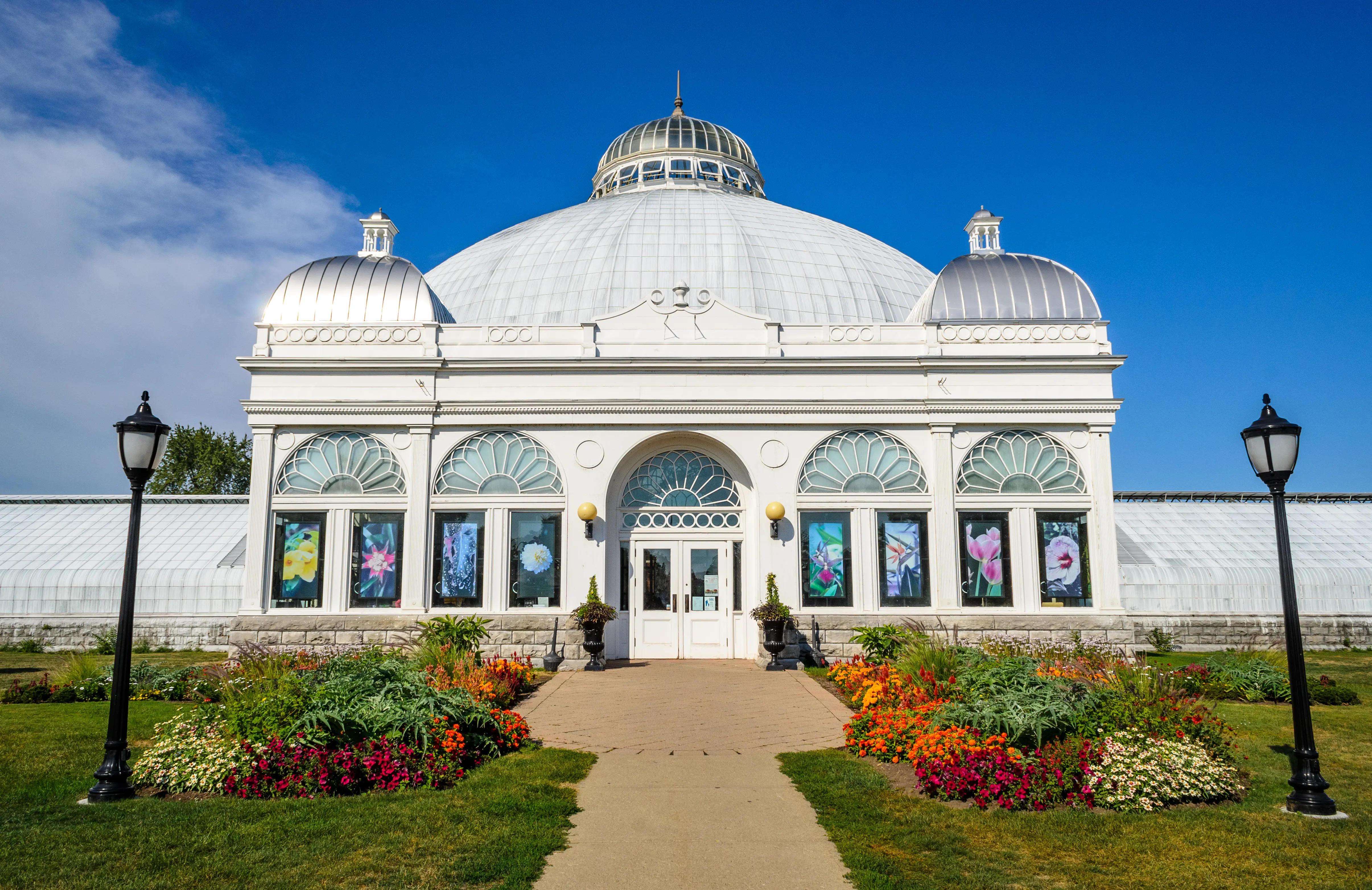Ornate greenhouse front facade and flowered entryway of the Buffalo and Erie County Botanical Gardens on a sunny day, New York