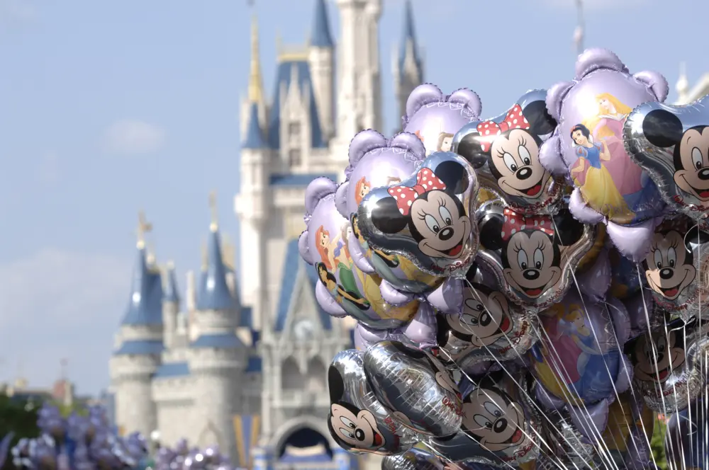 Magic Kingdom Park showing Cinderella Castle and Mickey balloons in Orlando, Florida.