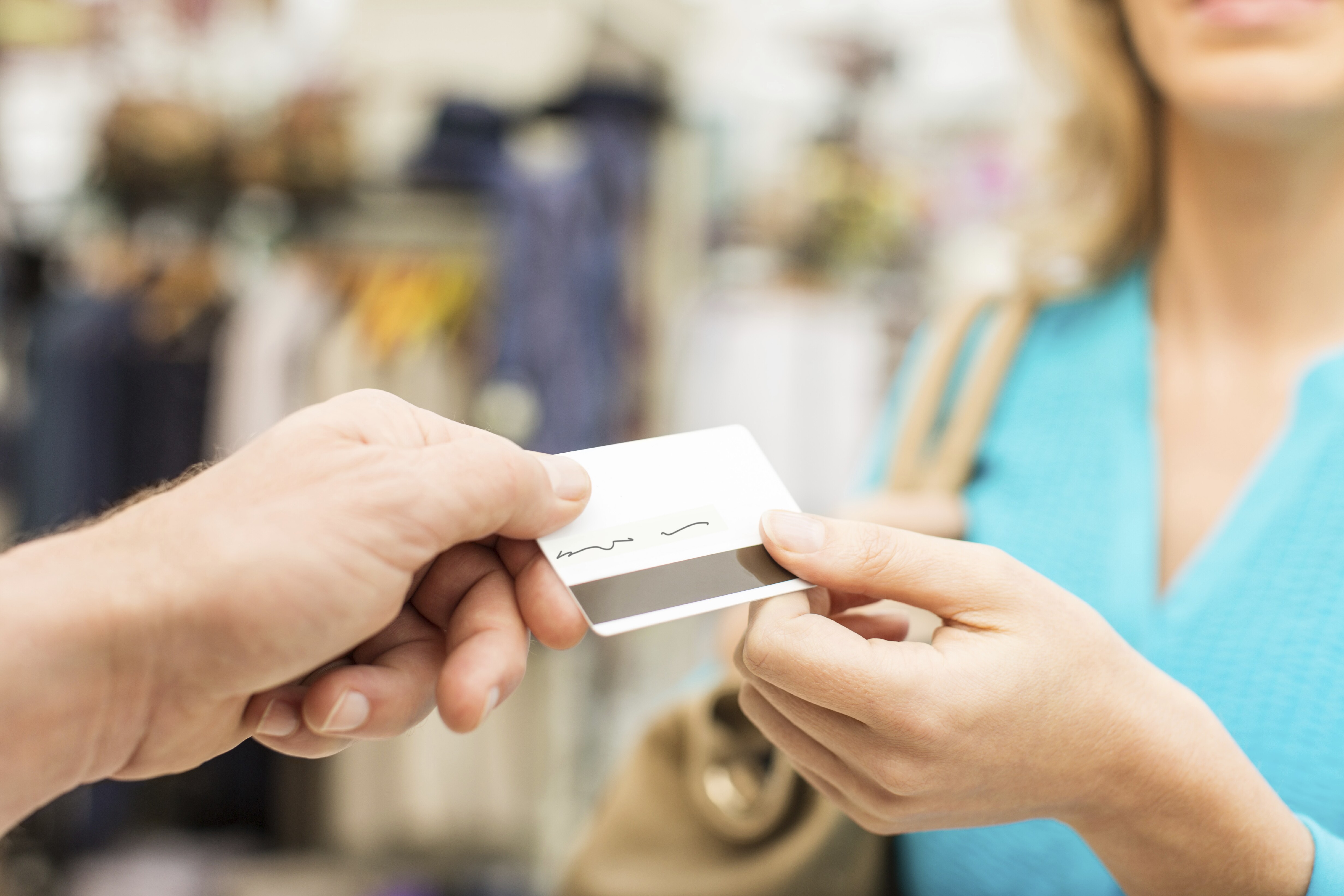 Shopping handing over her credit card to a cashier