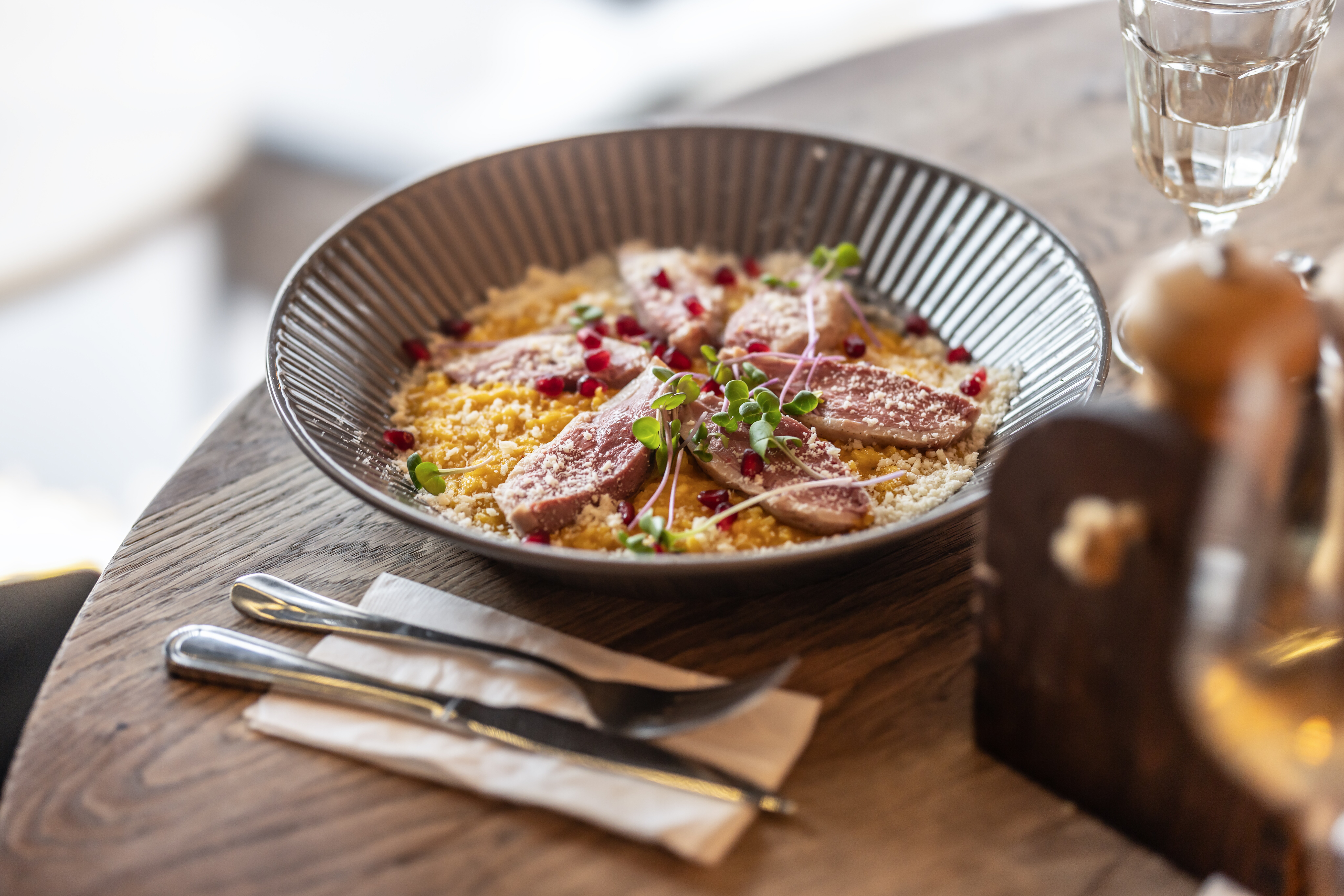 Closeup image of a dish of duck breast served over risotto.