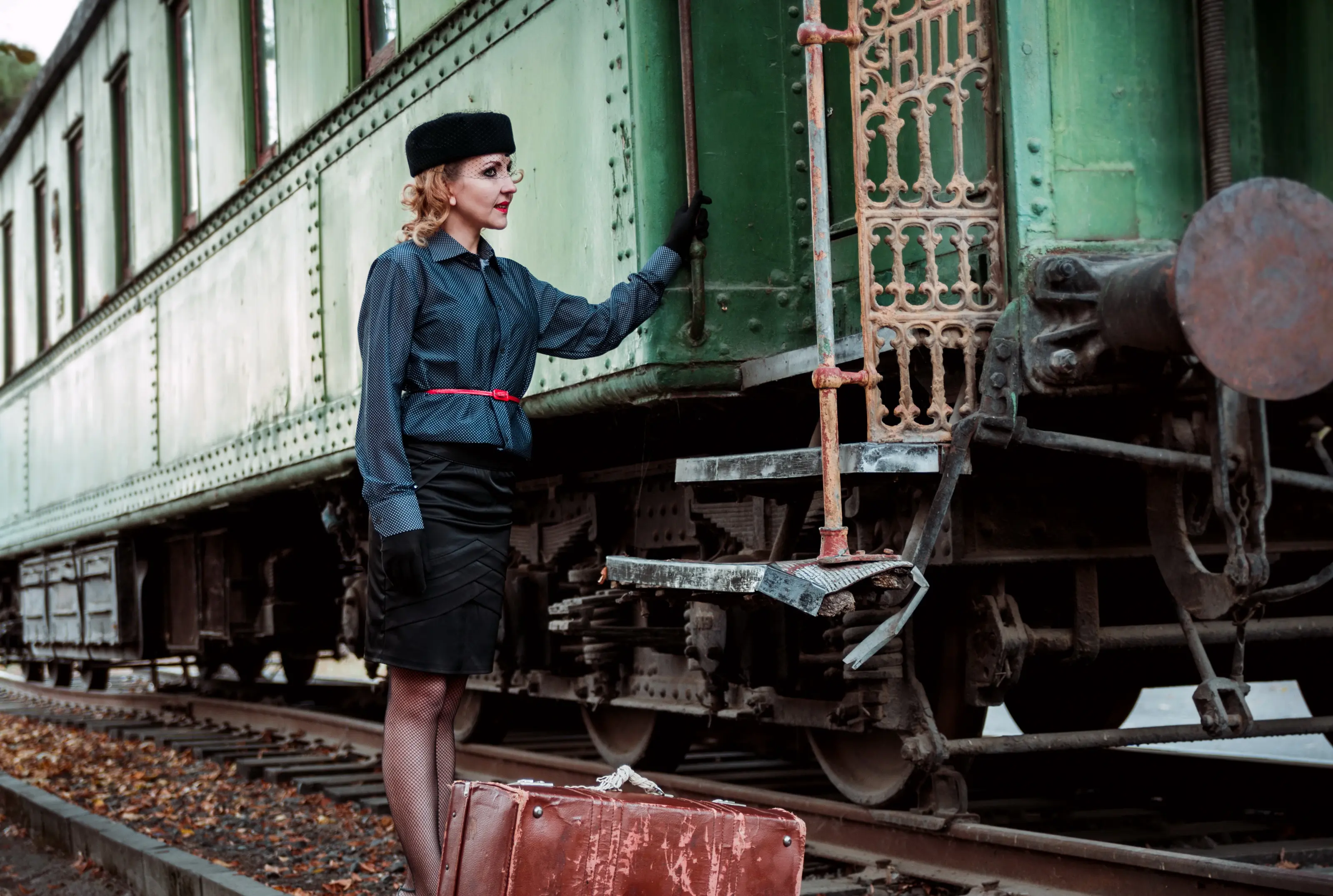 Image of a woman in vintage attire boarding an old train.