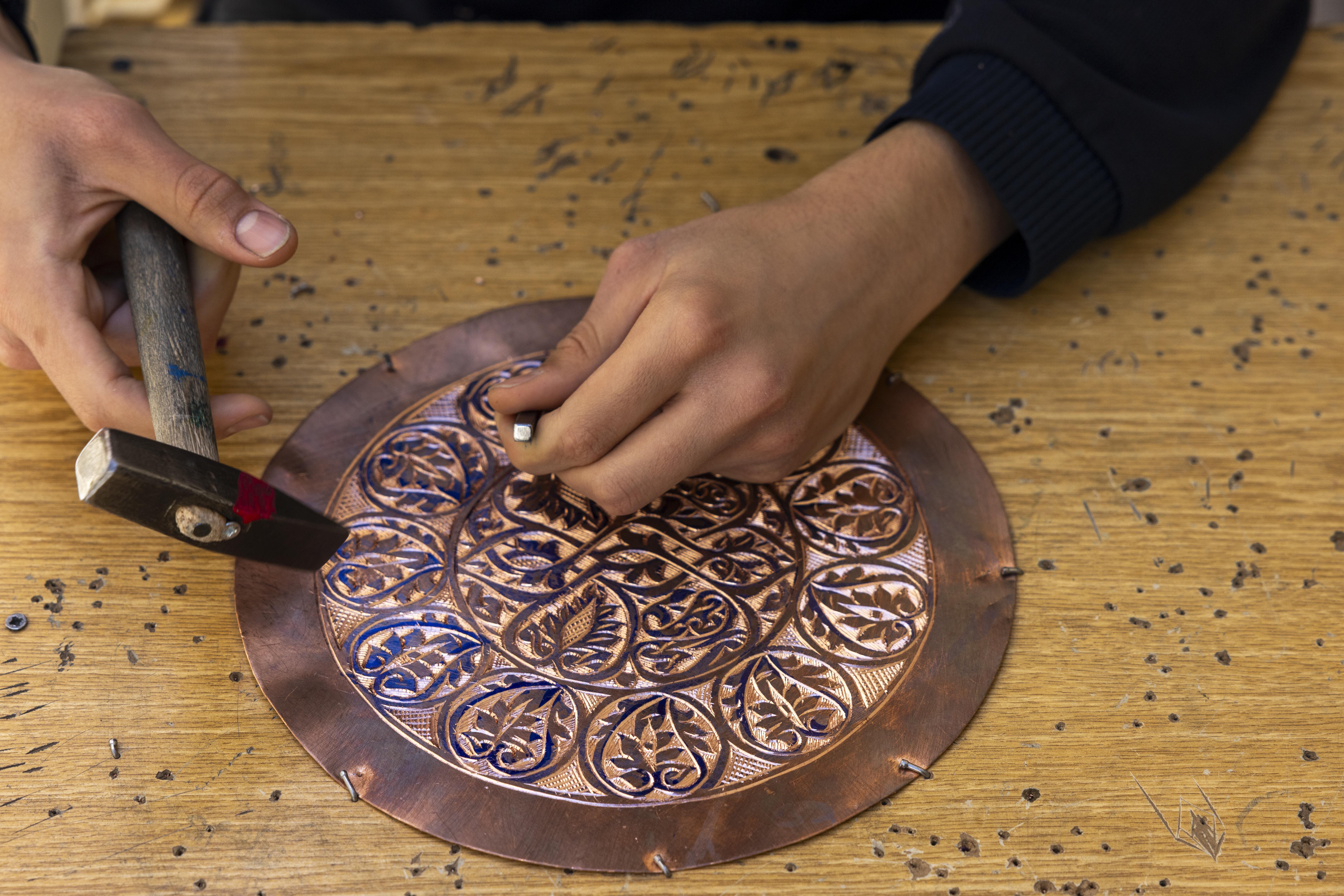 Photo of a man working on Copper artwork