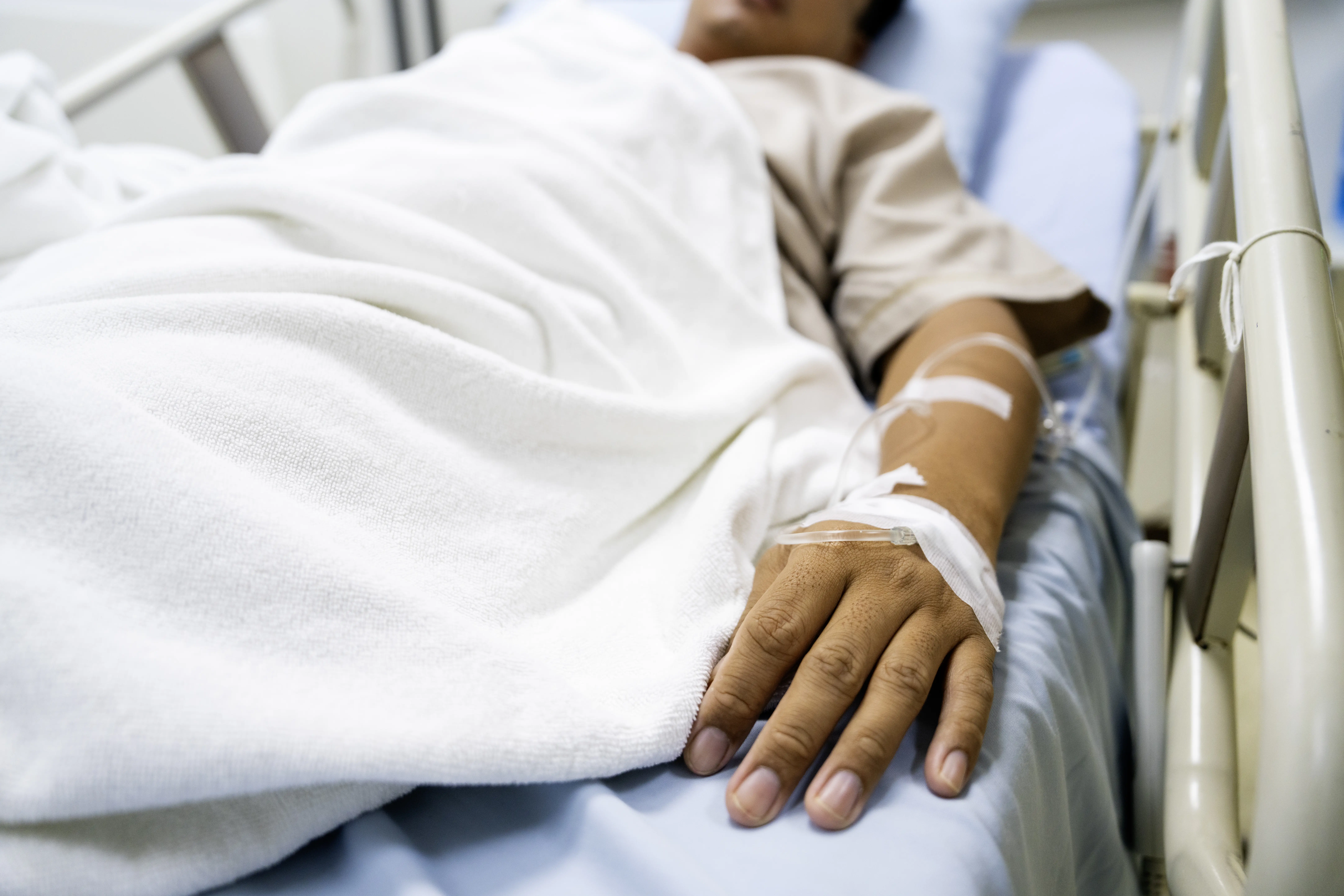 Image of a man lying in a hospital bed.