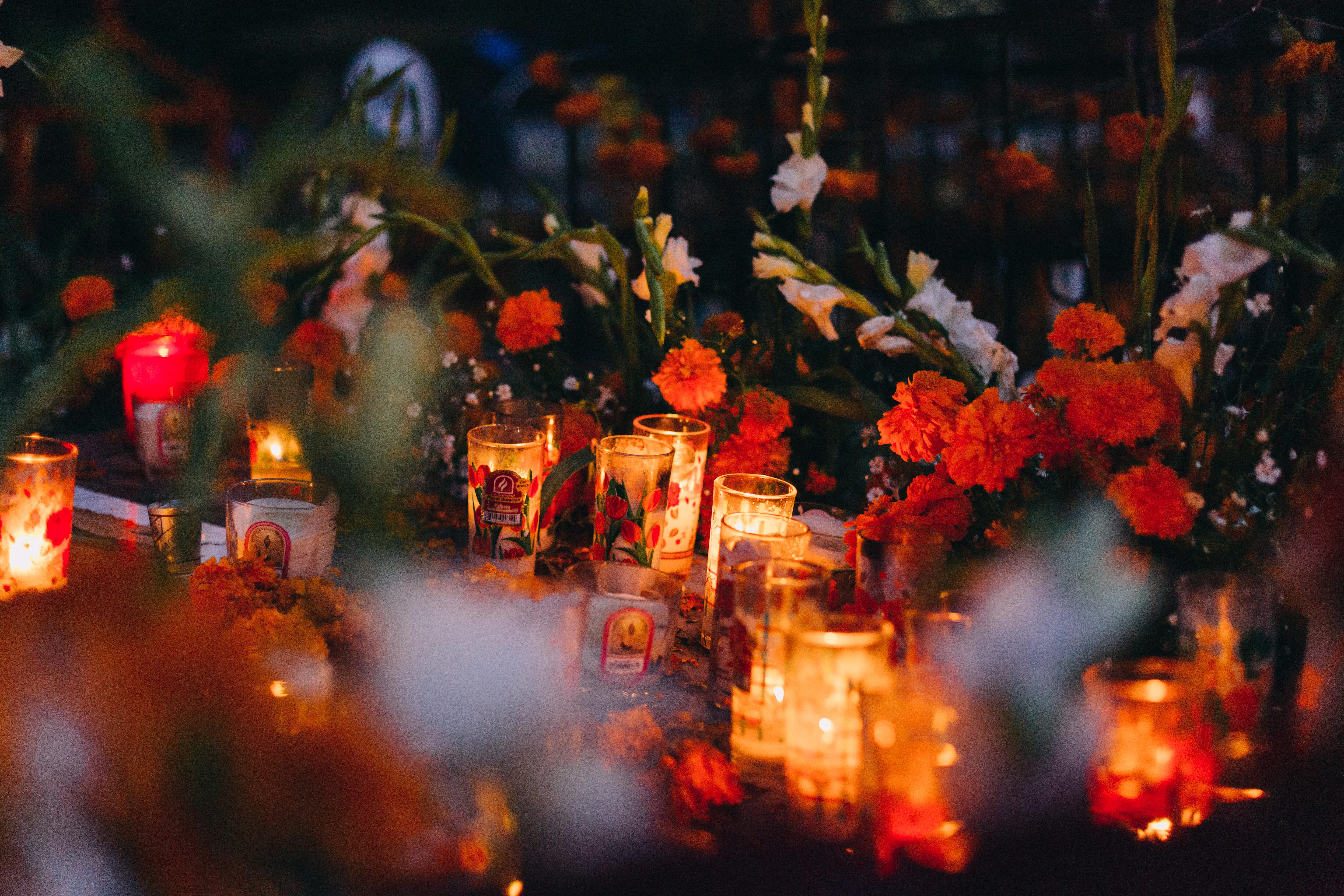Nighttime image of a display for Dia de los muertos adorned graves.