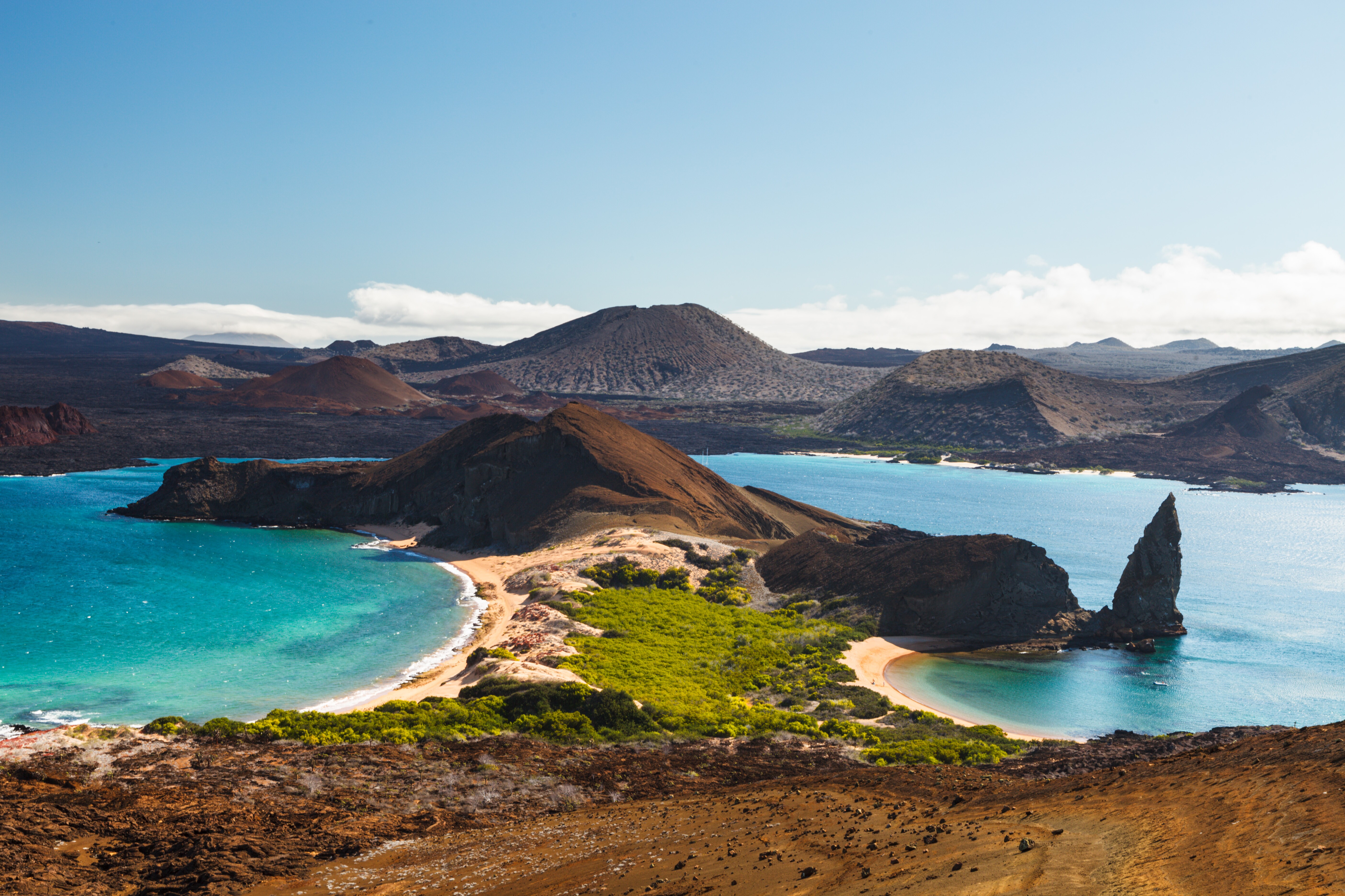 Scenic view on the volcanic landscape of Bartolome Island with famous Pinnacle Rock and Golden Beach, Galapagos Islands, Ecuador.