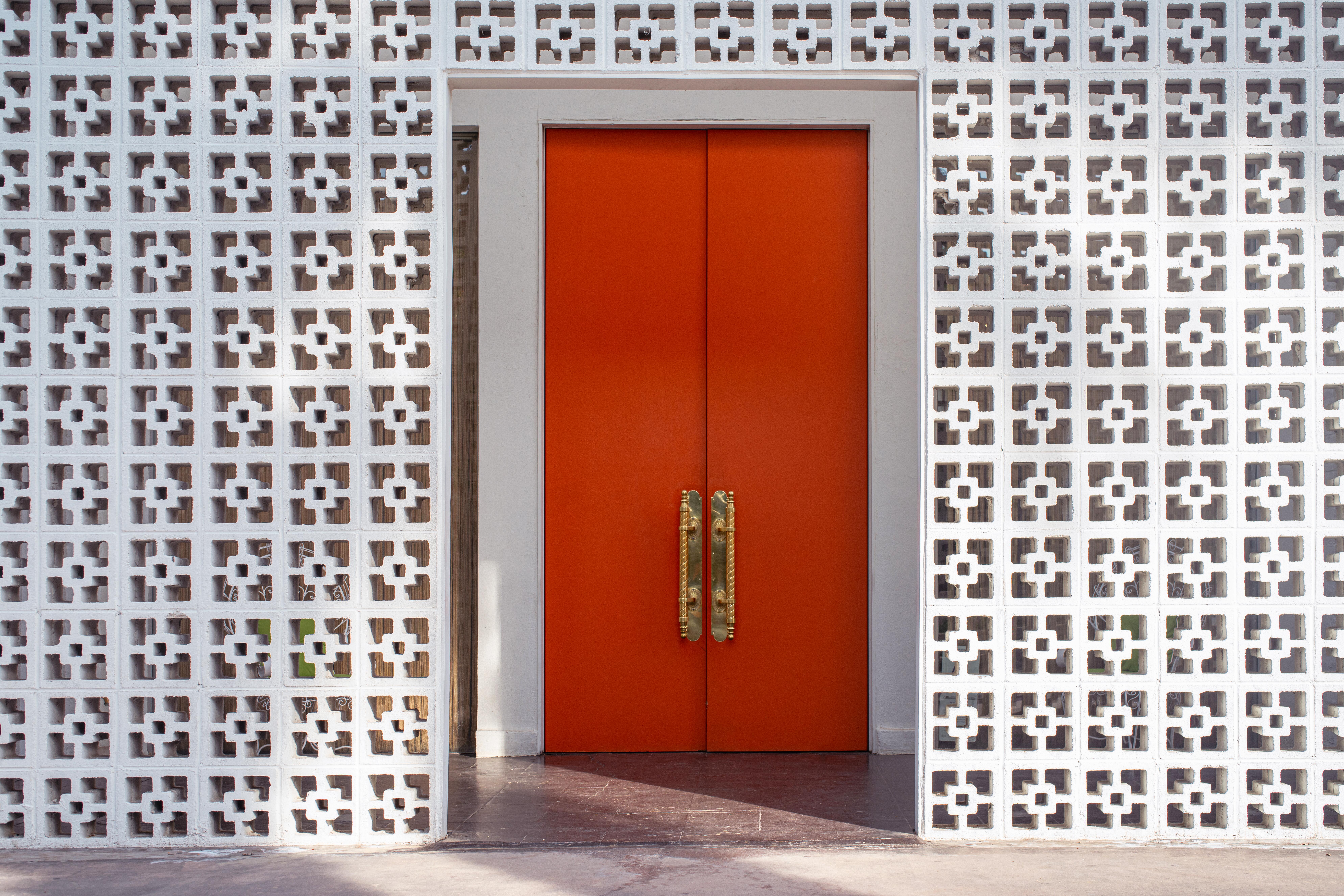 Orange door with white square pattern wall at Parker Palm Springs Hotel