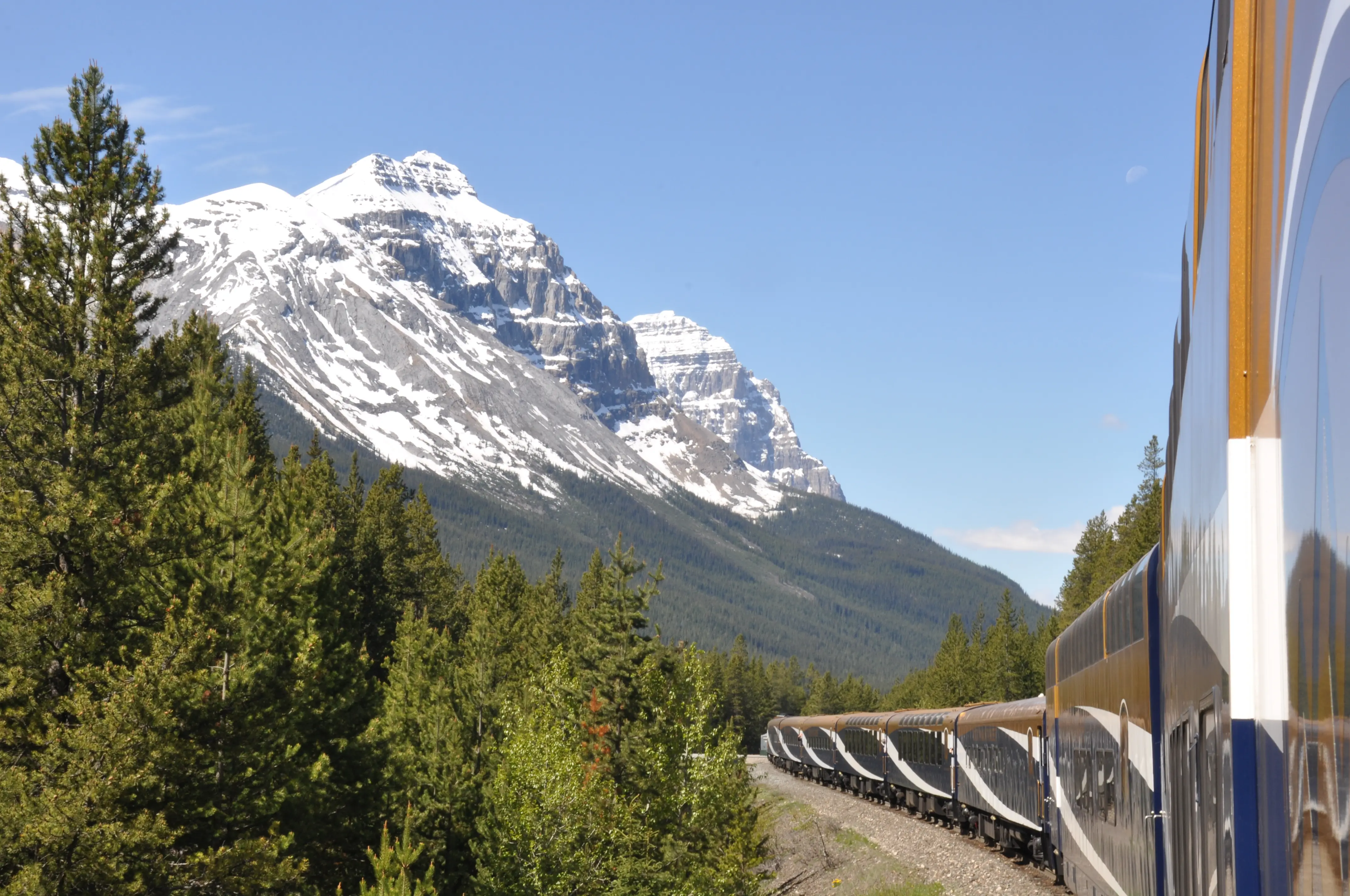 Image of the Rocky Mountaineer train with Rockies in the background.