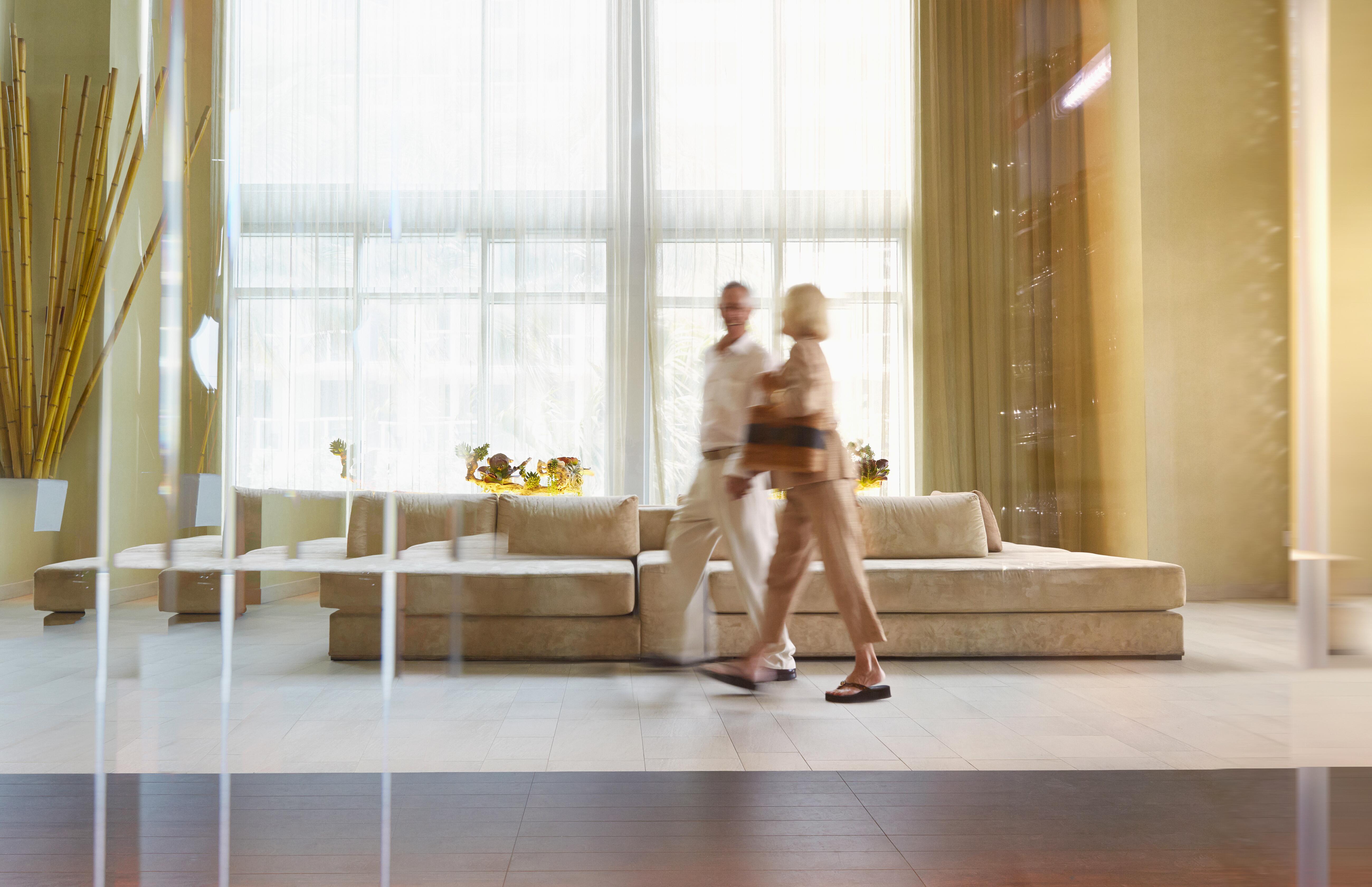 Couple walking in bright lit hotel lobby in daytime