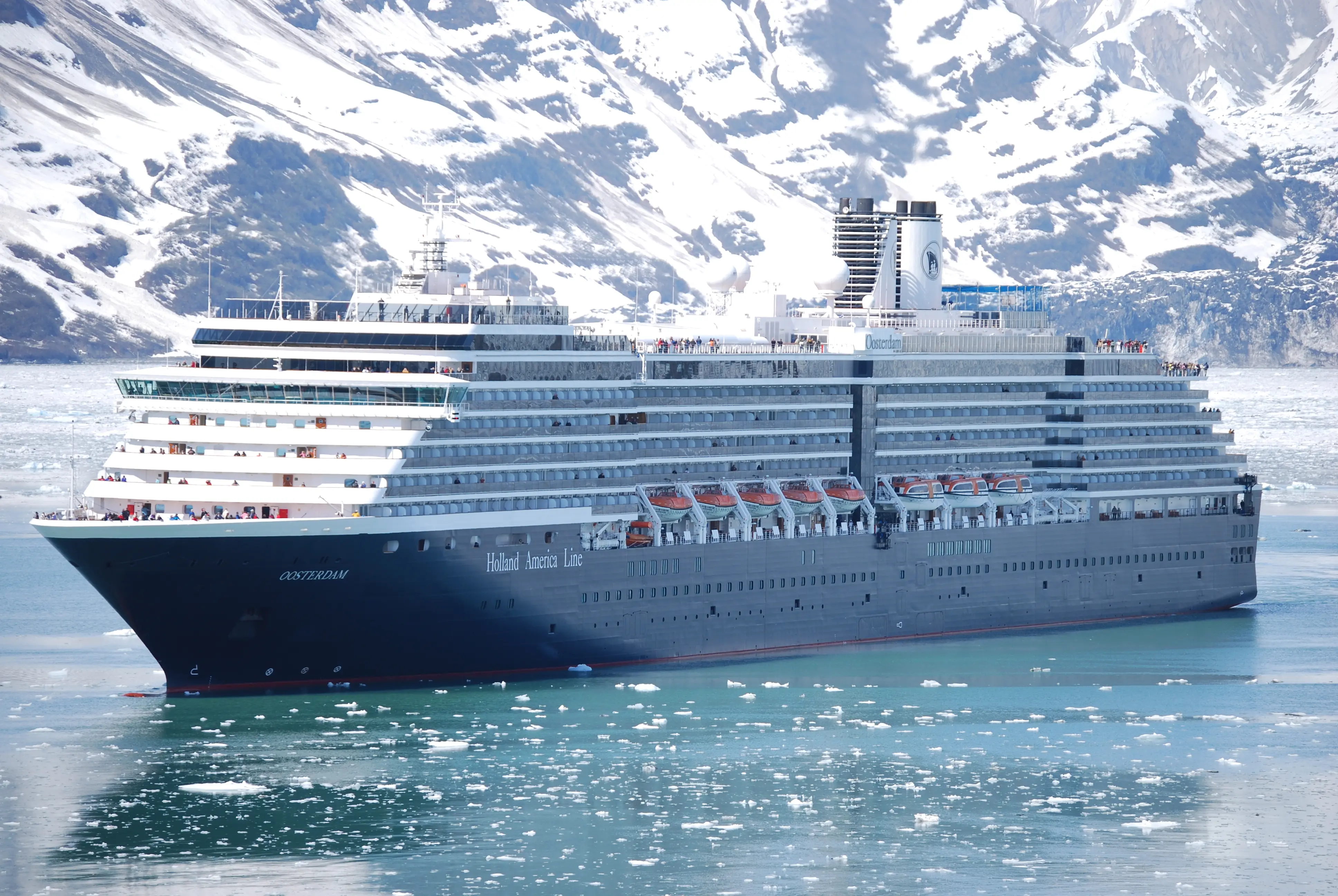 Exterior image of a Holland America cruise ship sailing in a snowy mountain environment.