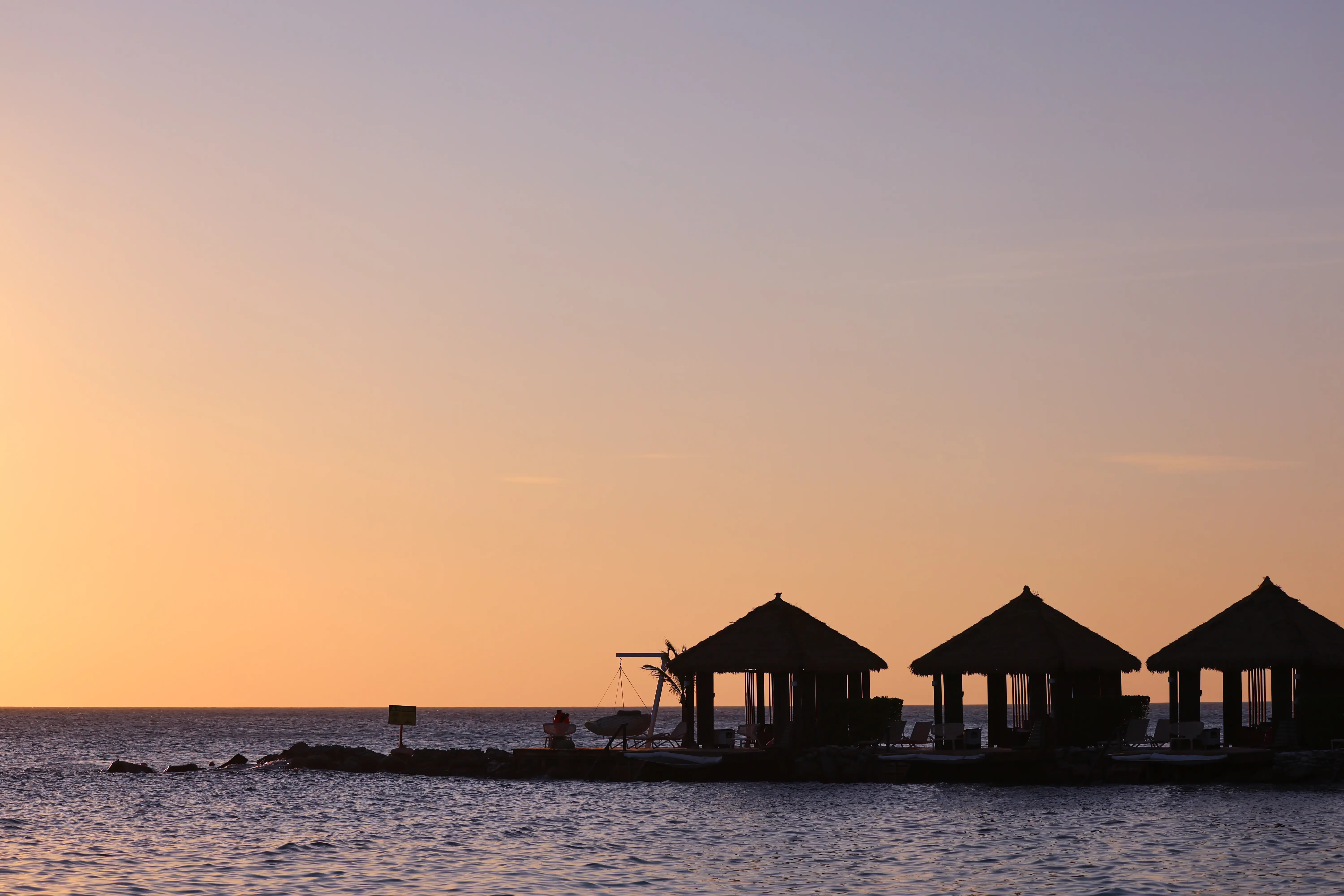 Images of villas on the beach during sunset in Aruba.