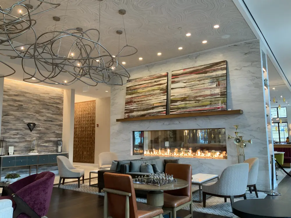 This art-filled boutique 4 Diamond Designated hotel set in the Hyde Park neighborhood of Chicago offers a stunning lobby white marble fireplace, ultra chic pendant lights, upscale sofas, canvas art, ornately designed ceiling, large stylish bathrooms and opulent showers.