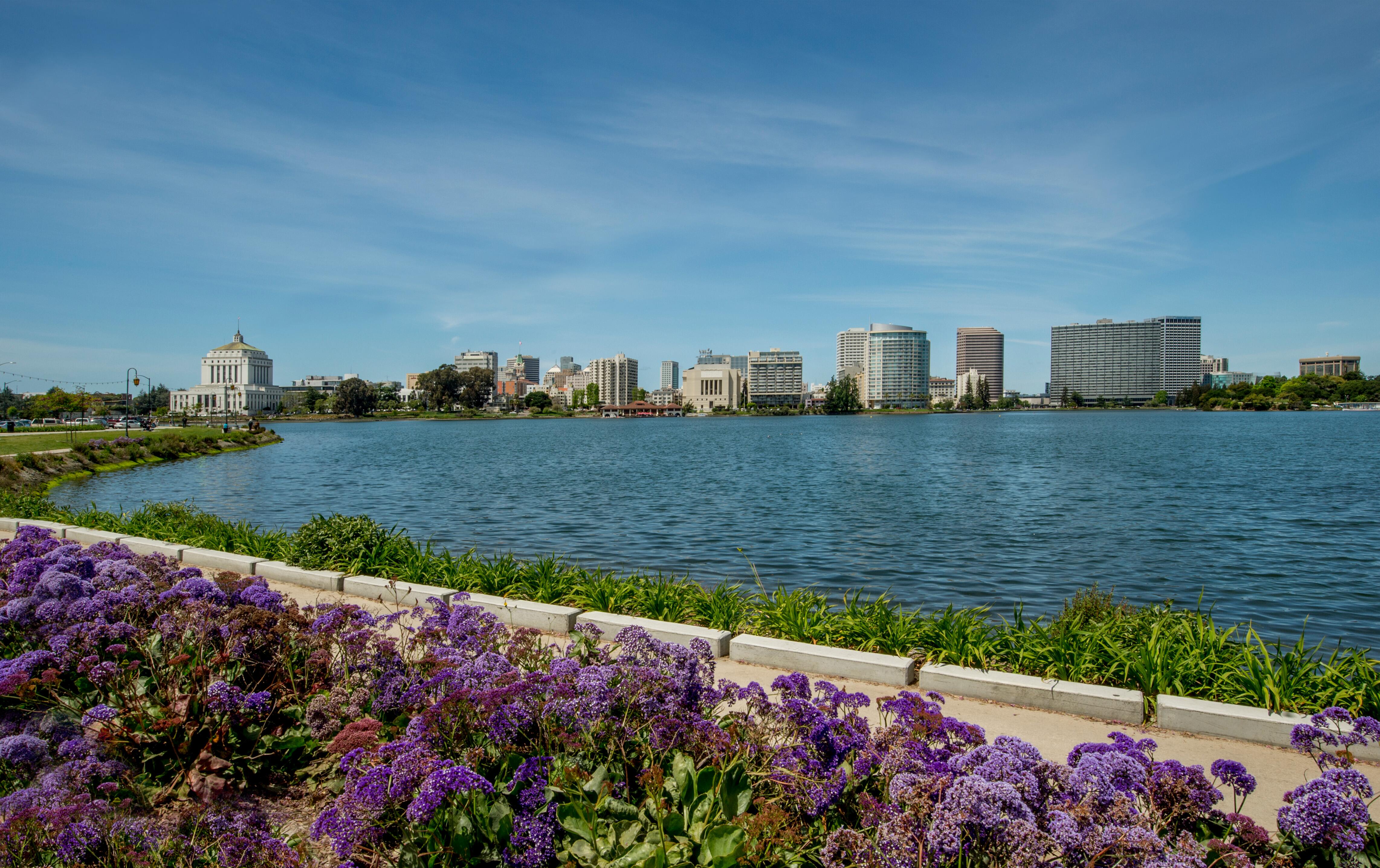 City of Oakland, California with Lake Merritt and walking path in foreground.