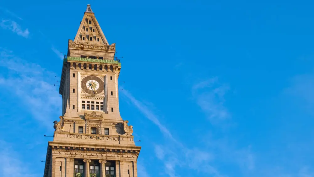 The upper portion of the Custom House Tower in Boston with the sky in the background.