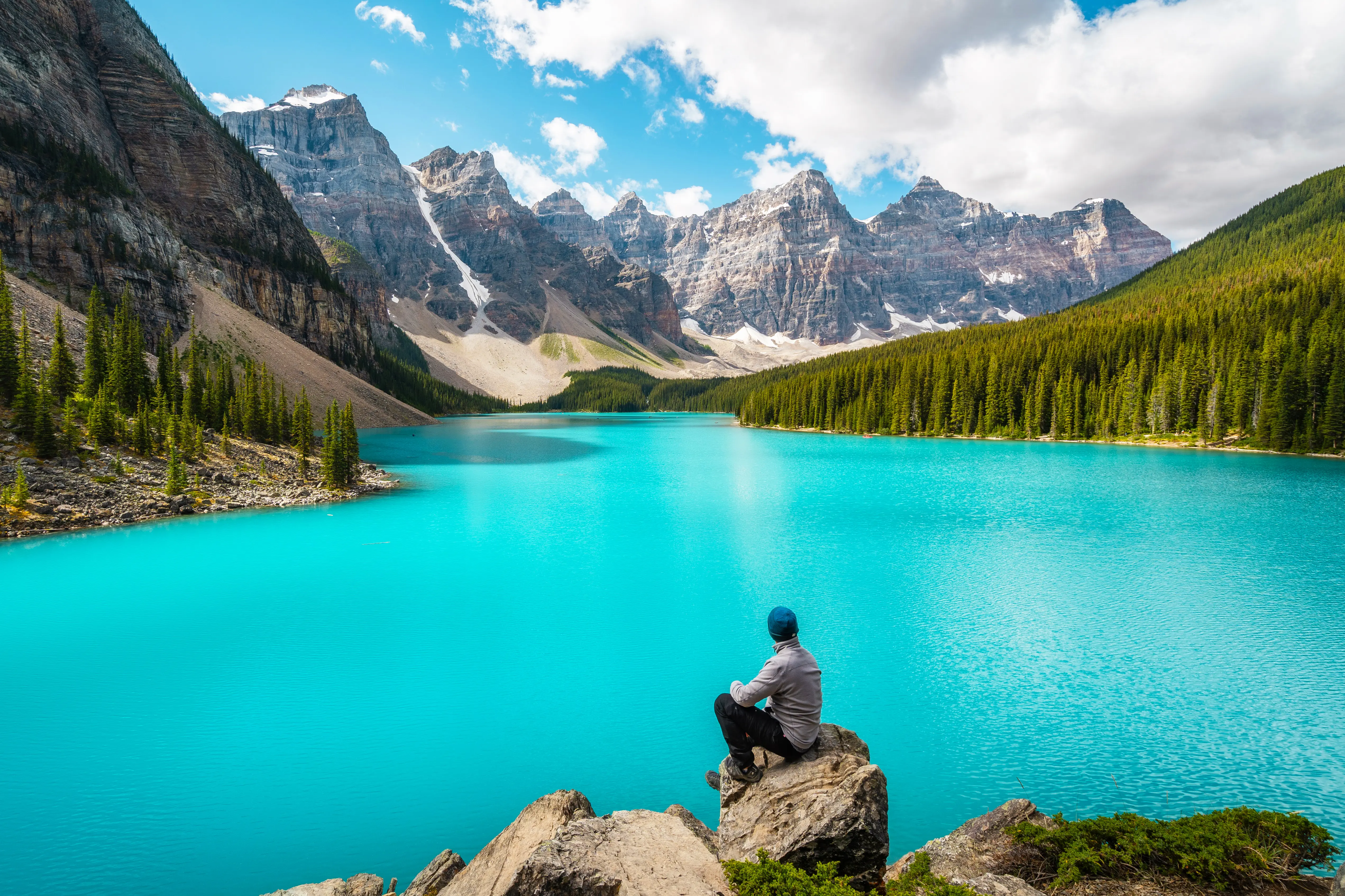 Hiker sitting on rock, taking in the view at Banff National Park in daytime