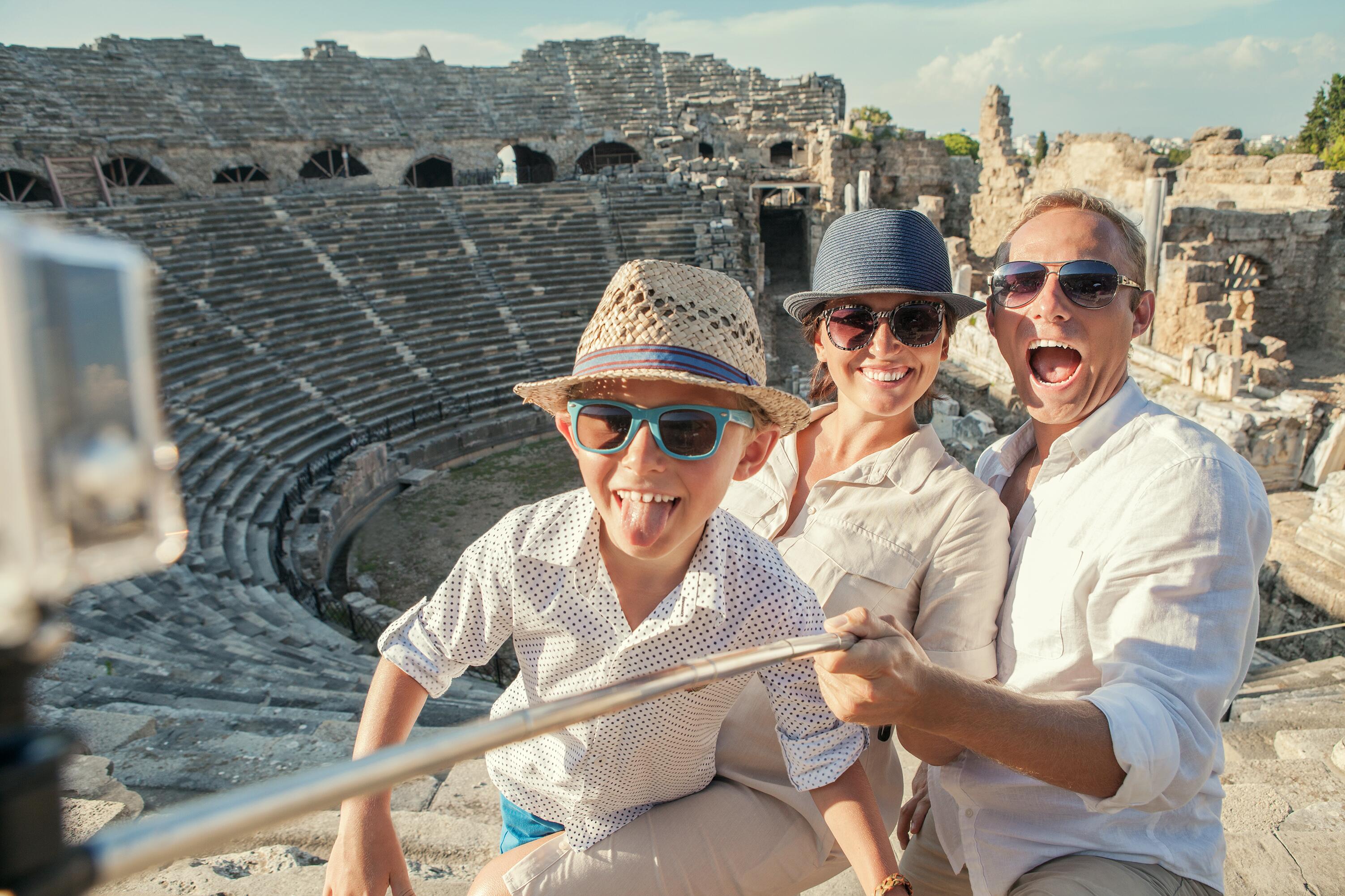 Young positive family take a vacation photo on the Side amphitheater  view
