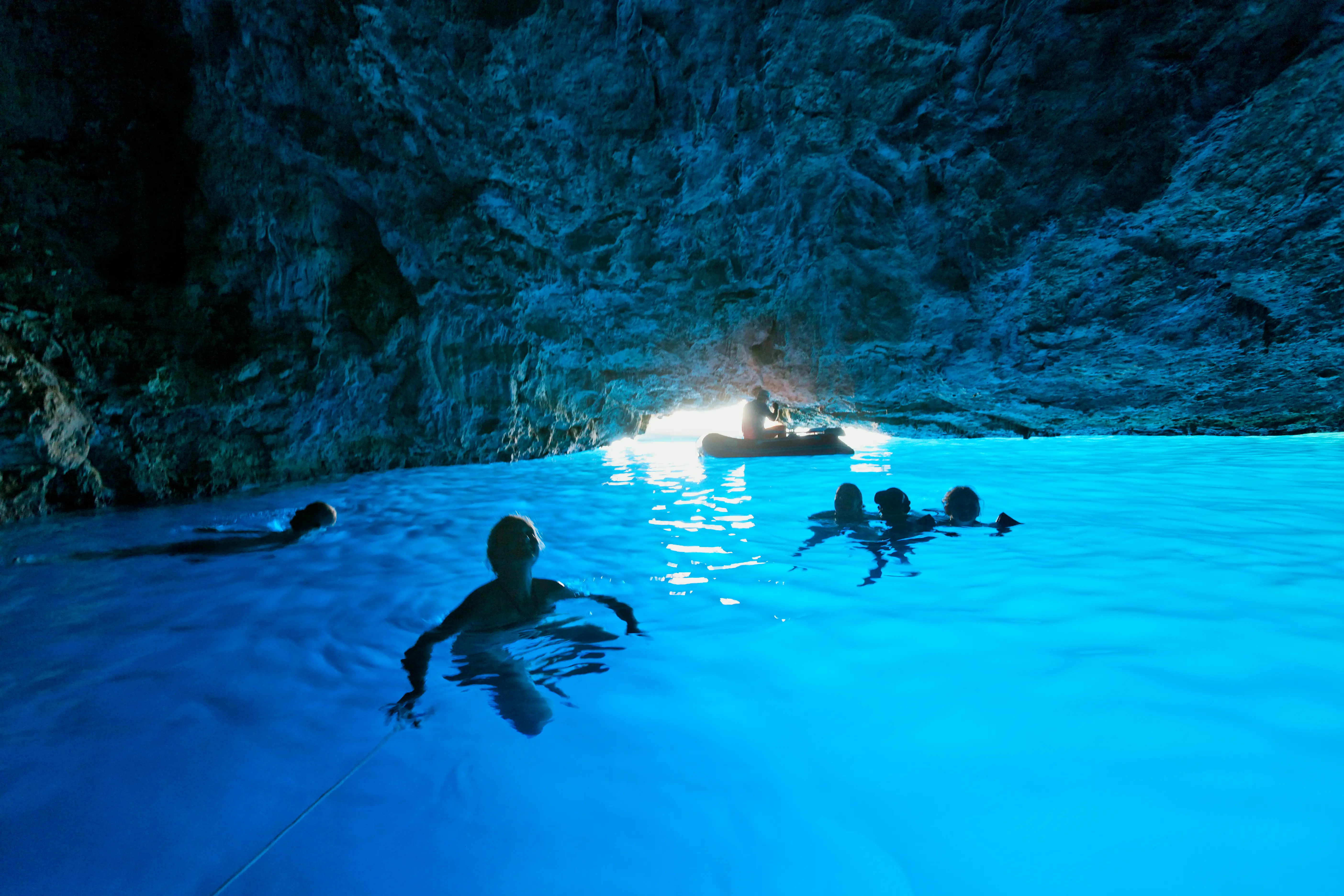Image of people swimming in an ocean cave.